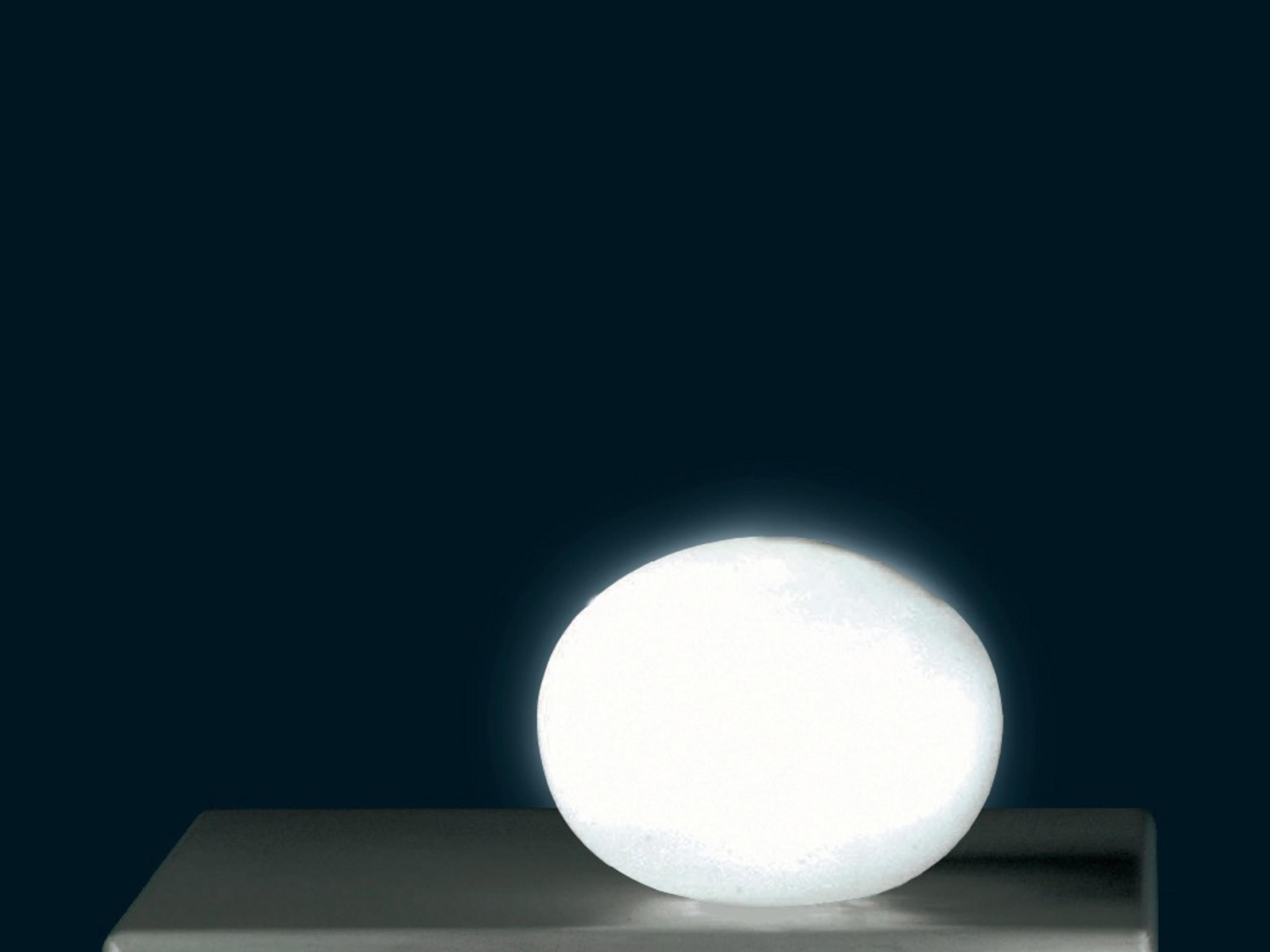 Świecąca biała kula na ciemnym tle.