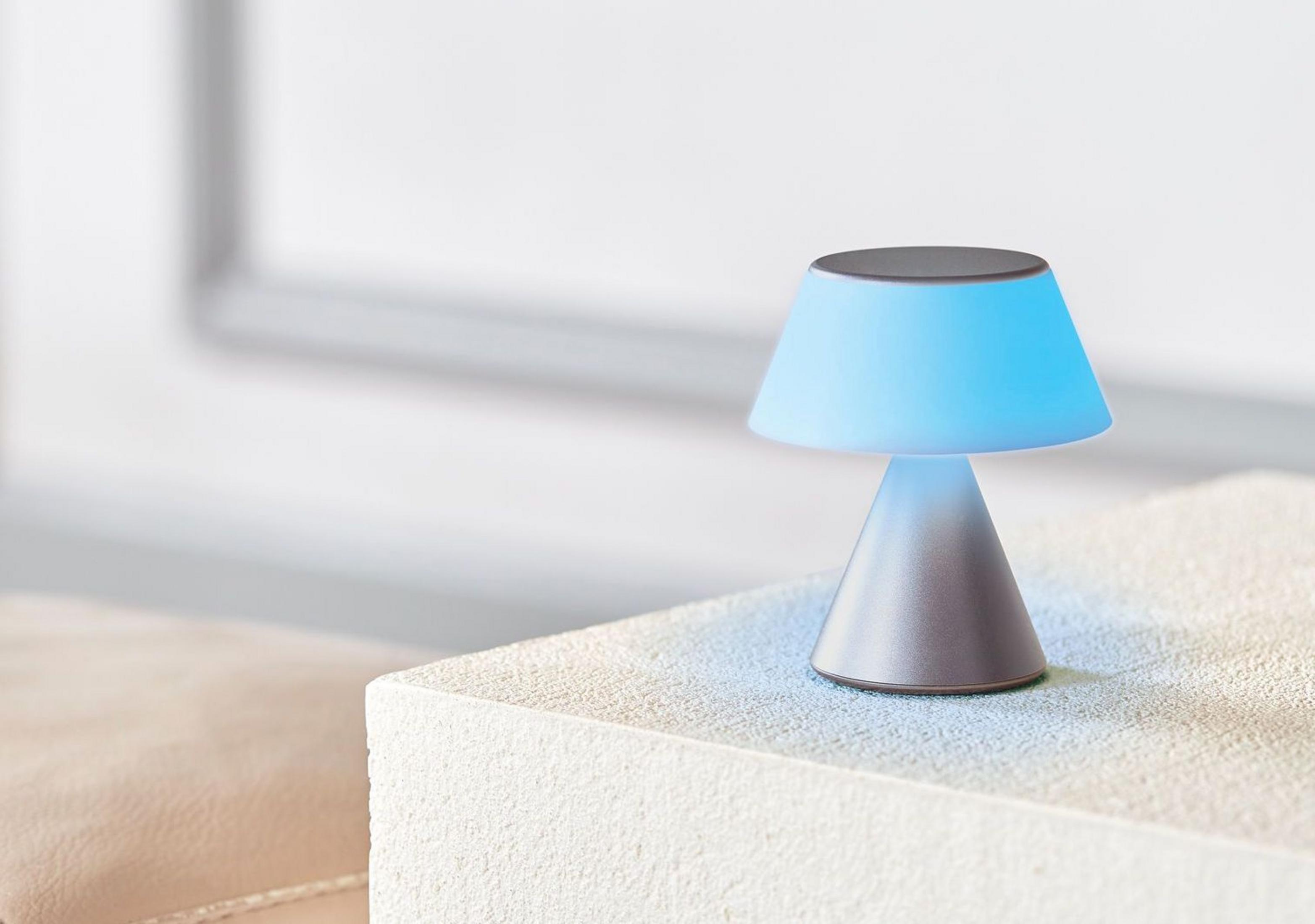 Una piccola lampada con luce blu è su un tavolo chiaro.