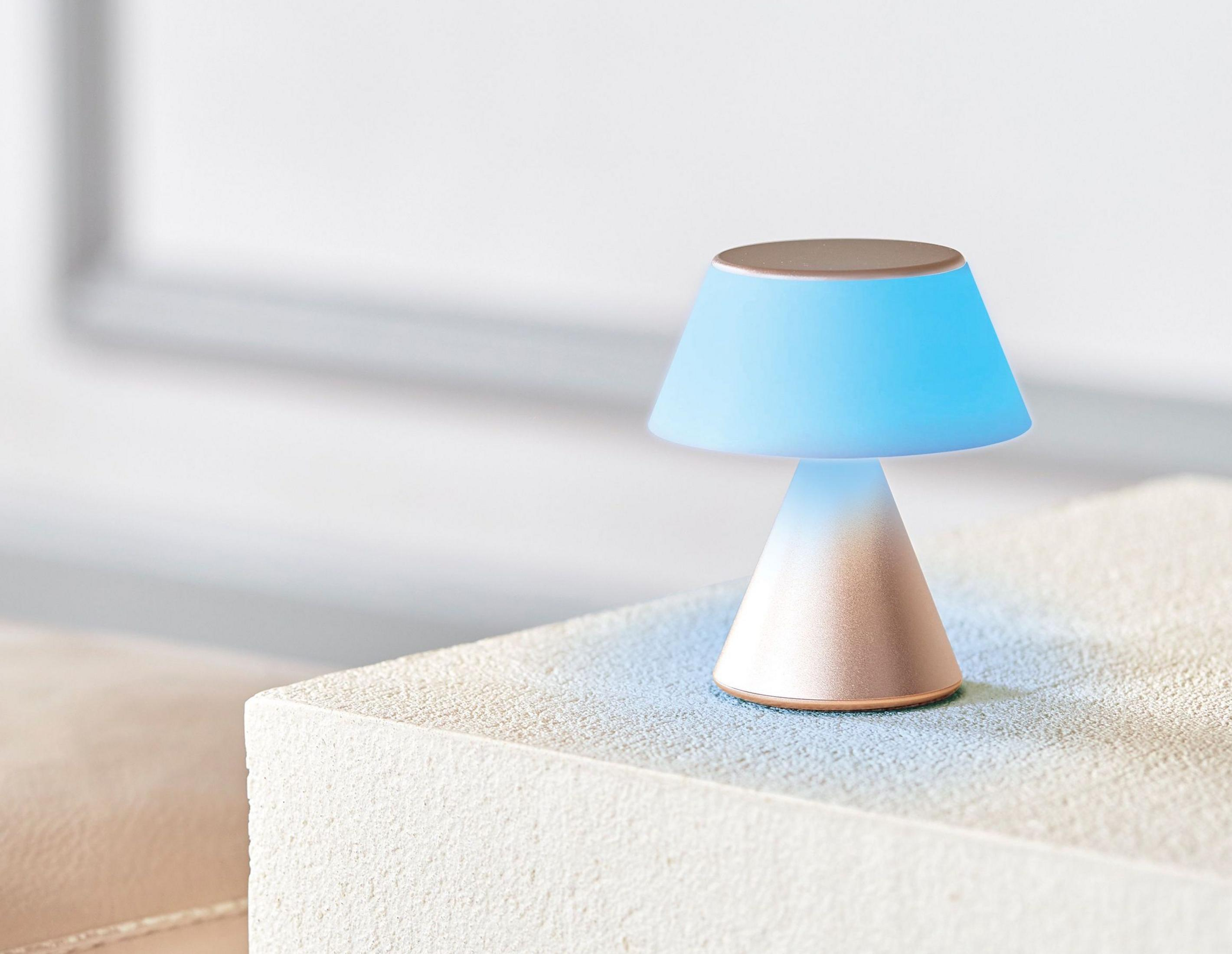 Una piccola lampada con luce blu siede su una superficie di pietra.