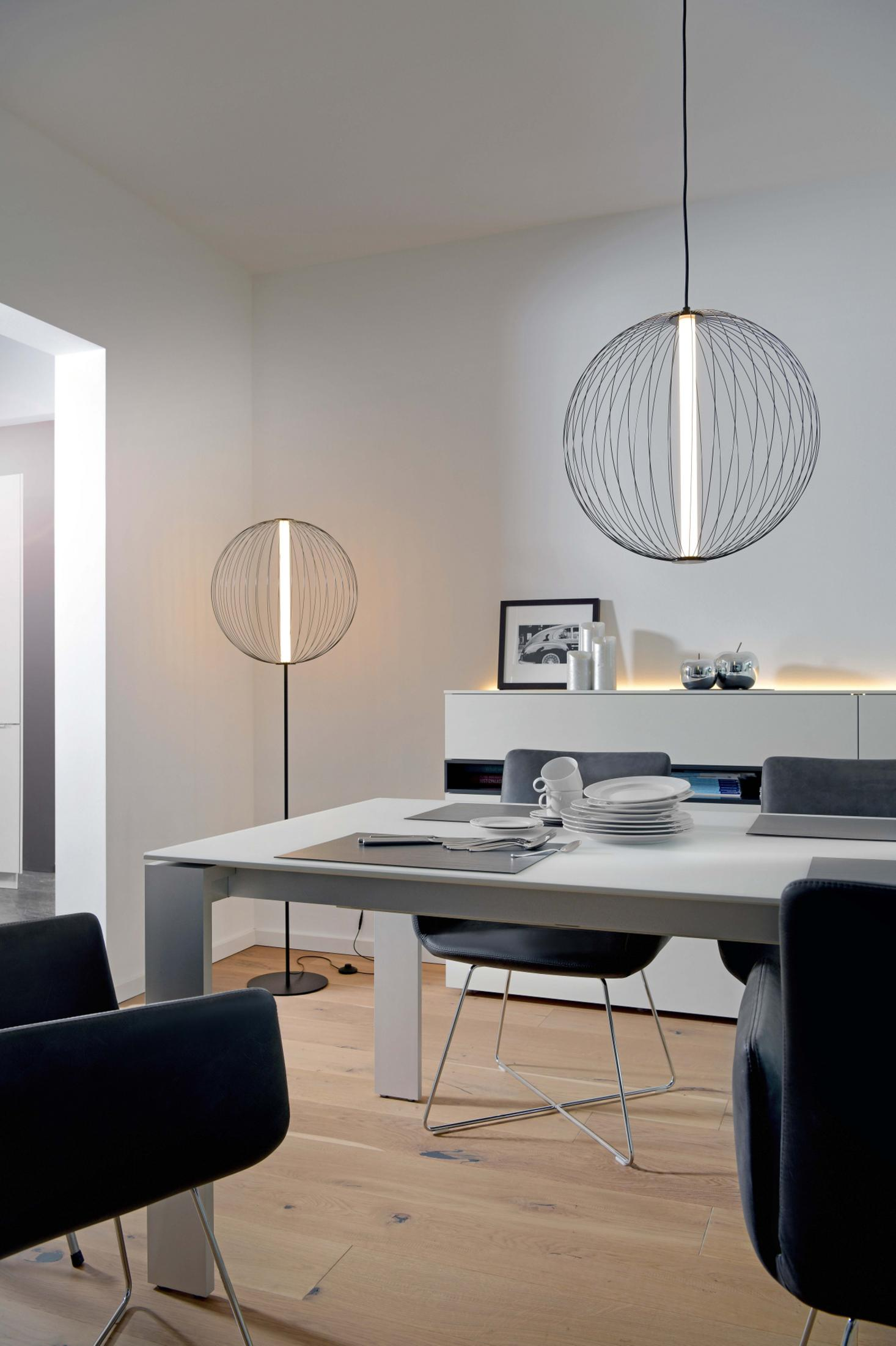 Table de salle à manger avec sièges et éclairage moderne.