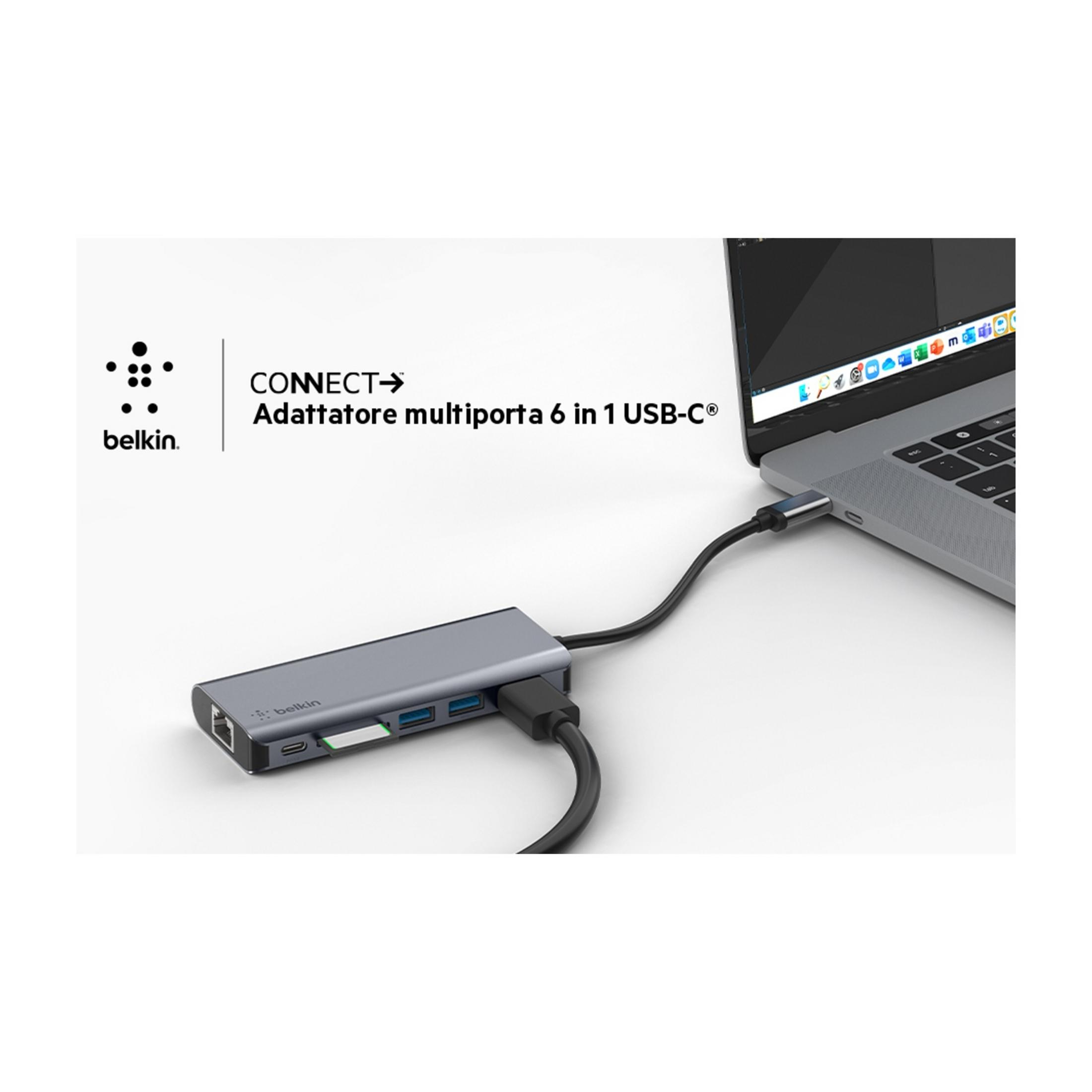 Un concentrador Belkin USB-C gris con múltiples puertos está conectado a un portátil.