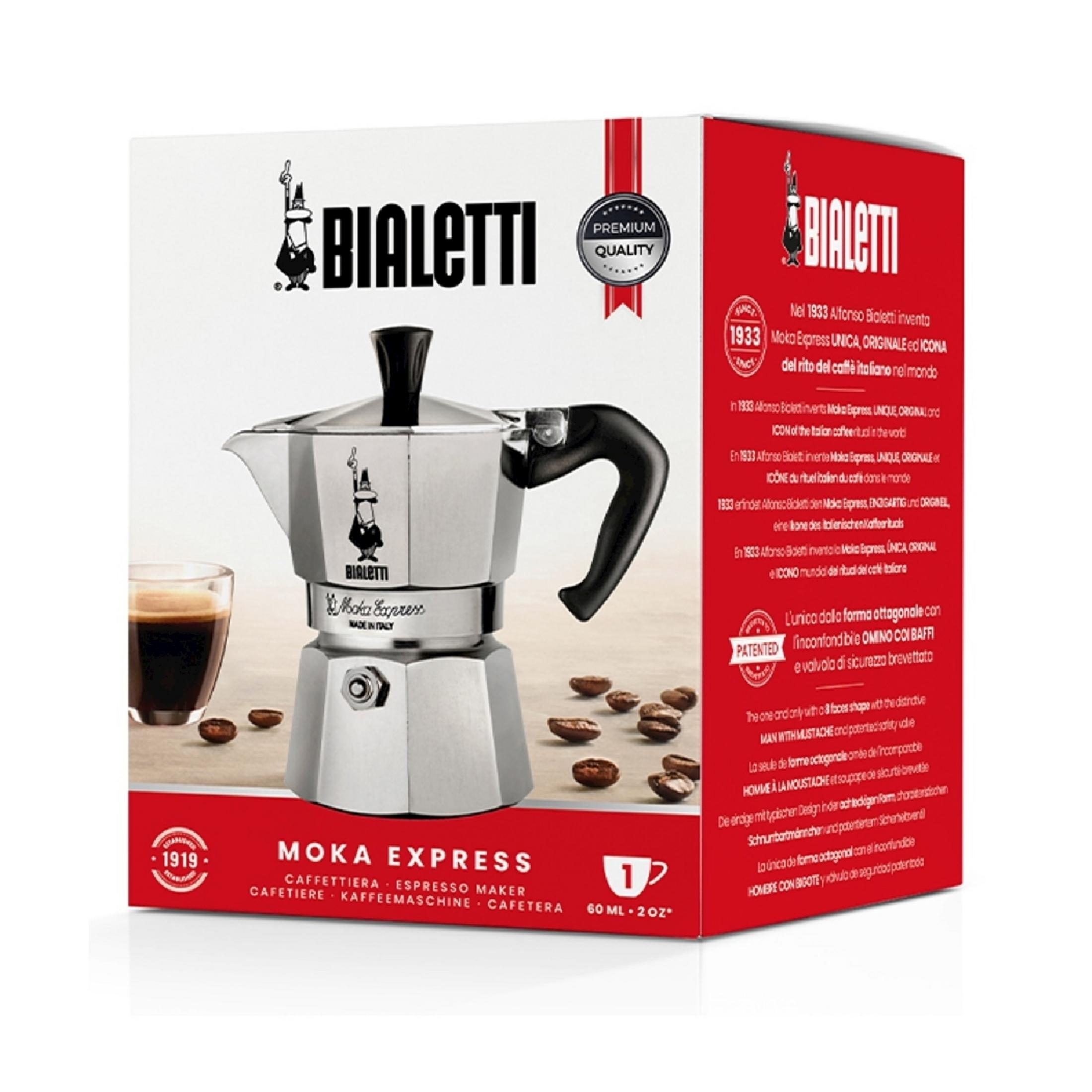 Bialetti Moka Express Espressokocher mit Glas und Kaffeebohnen auf dem Tisch.
