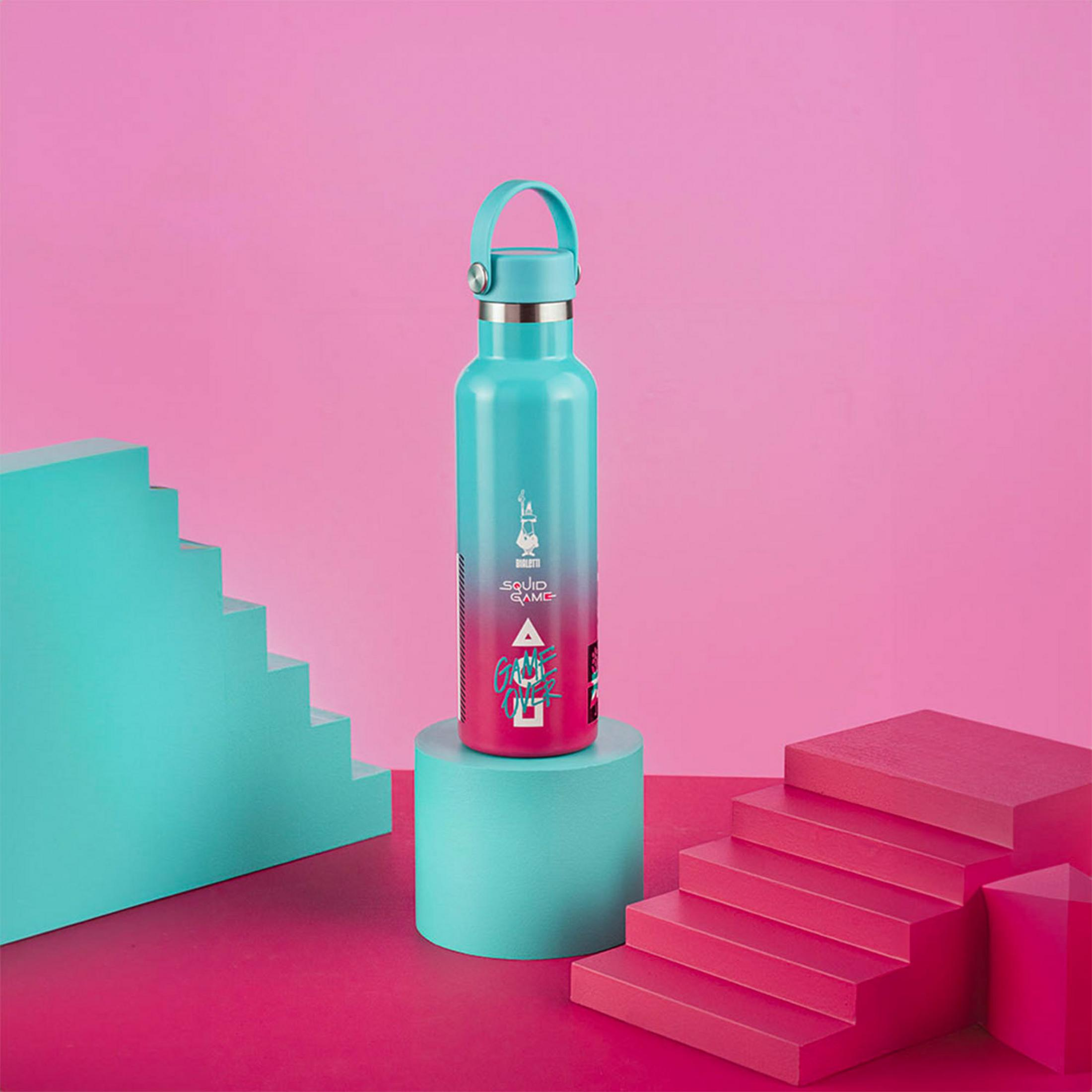Una botella de agua turquesa con diseño de Squid Game descansa sobre un pedestal.
