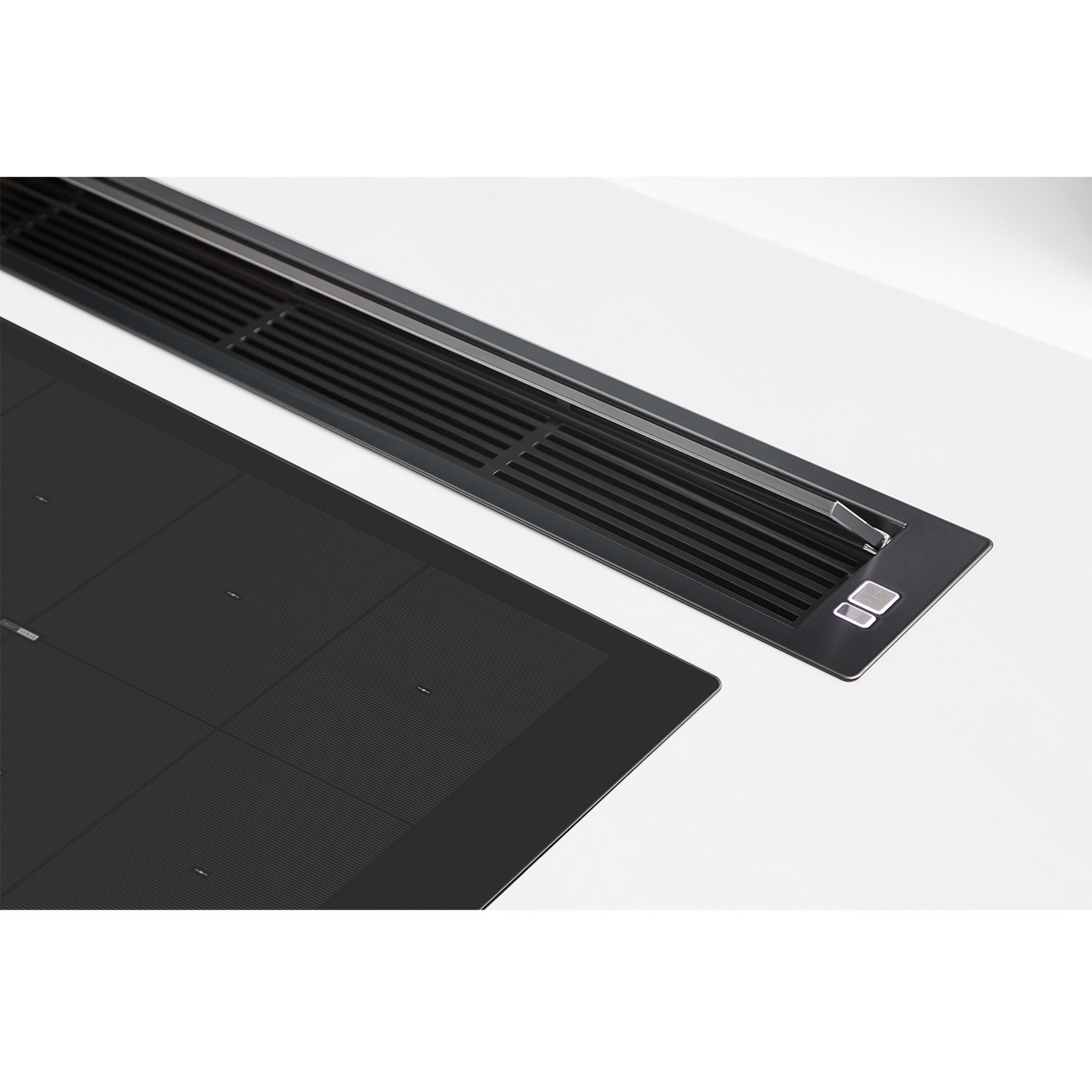 Czarna płyta indukcyjna i czarny okap z otworami wentylacyjnymi.