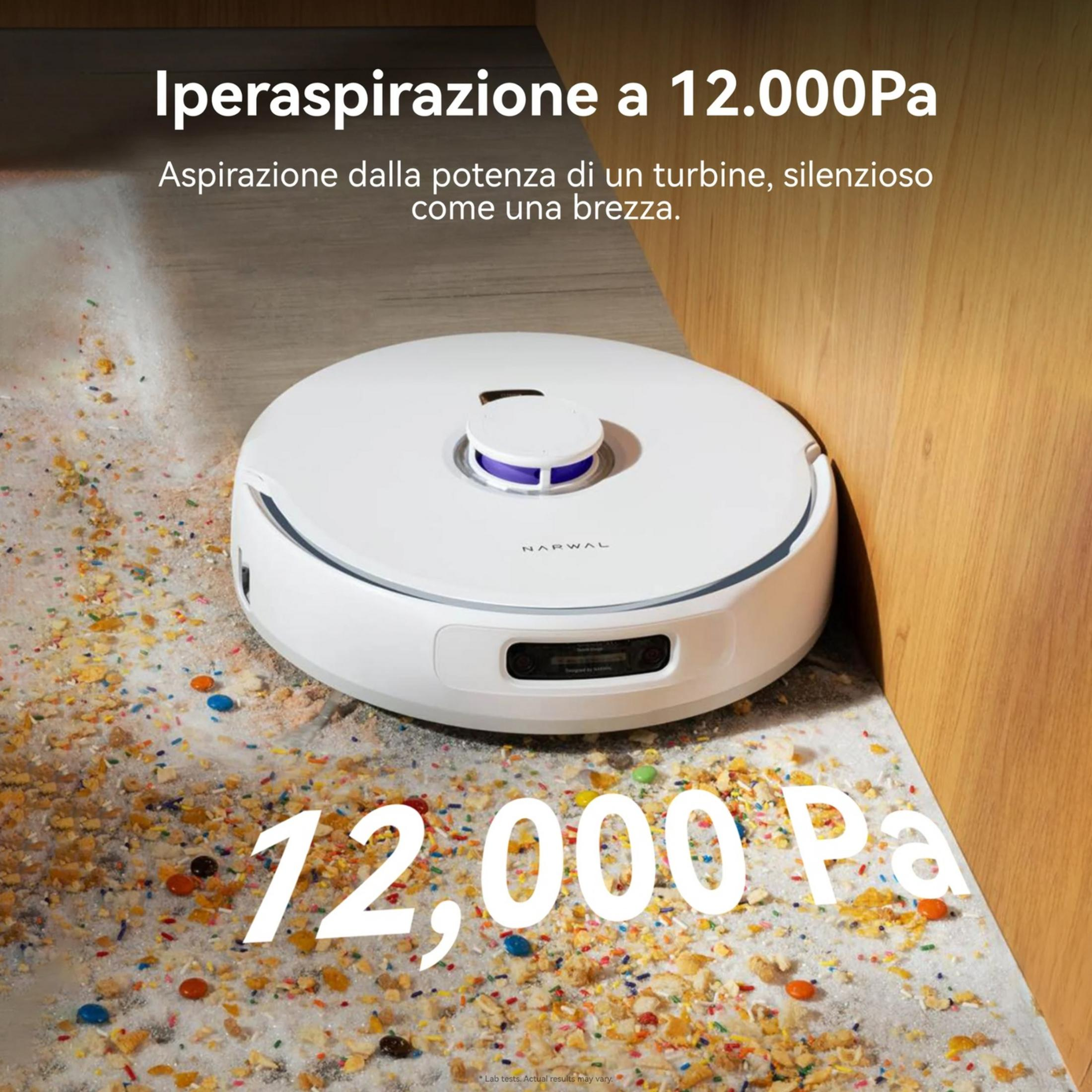Un robot aspirapolvere bianco pulisce un pavimento cosparso di zuccherini e briciole.
