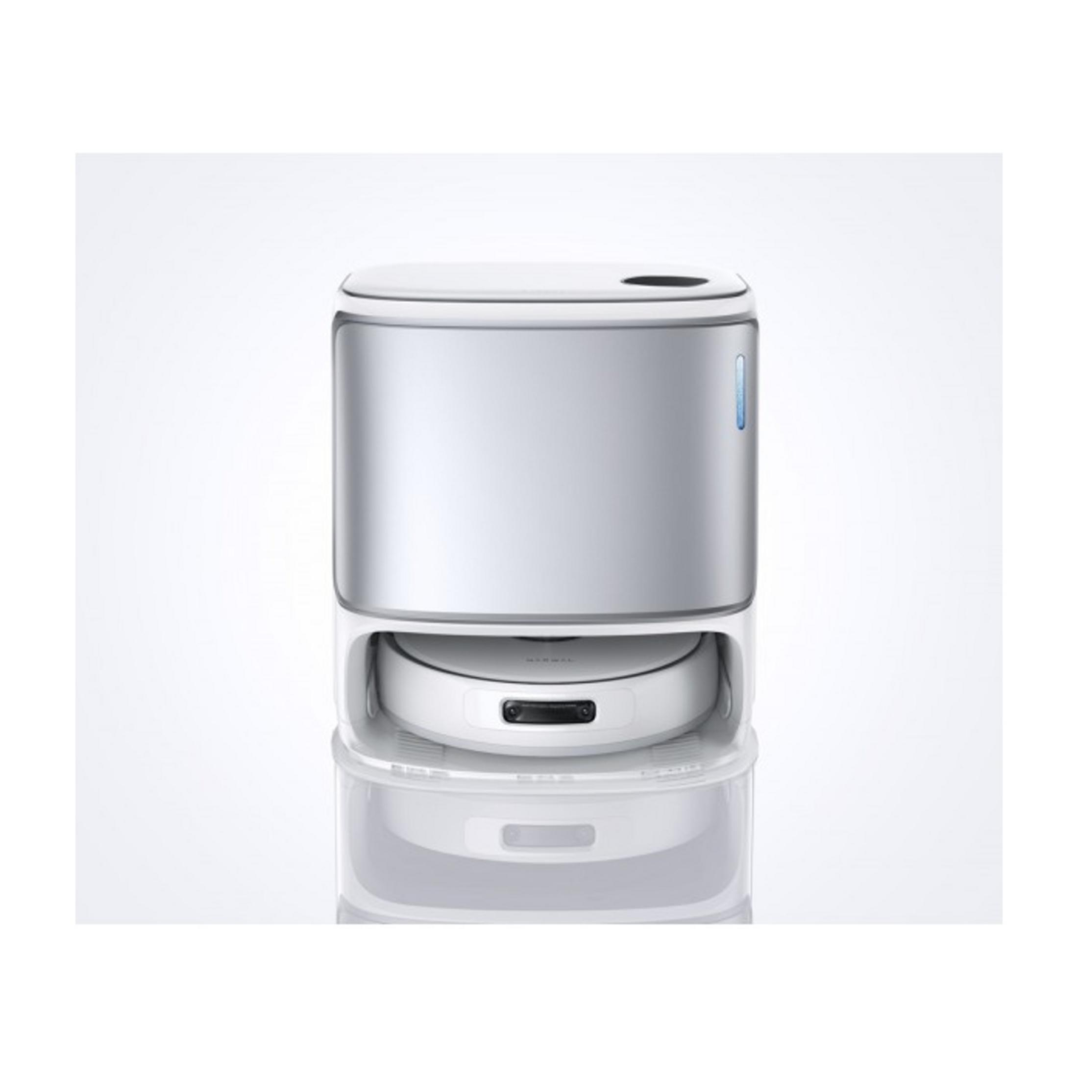 Biały robot sprzątający ze srebrnym cylindrem stoi na stacji ładującej.