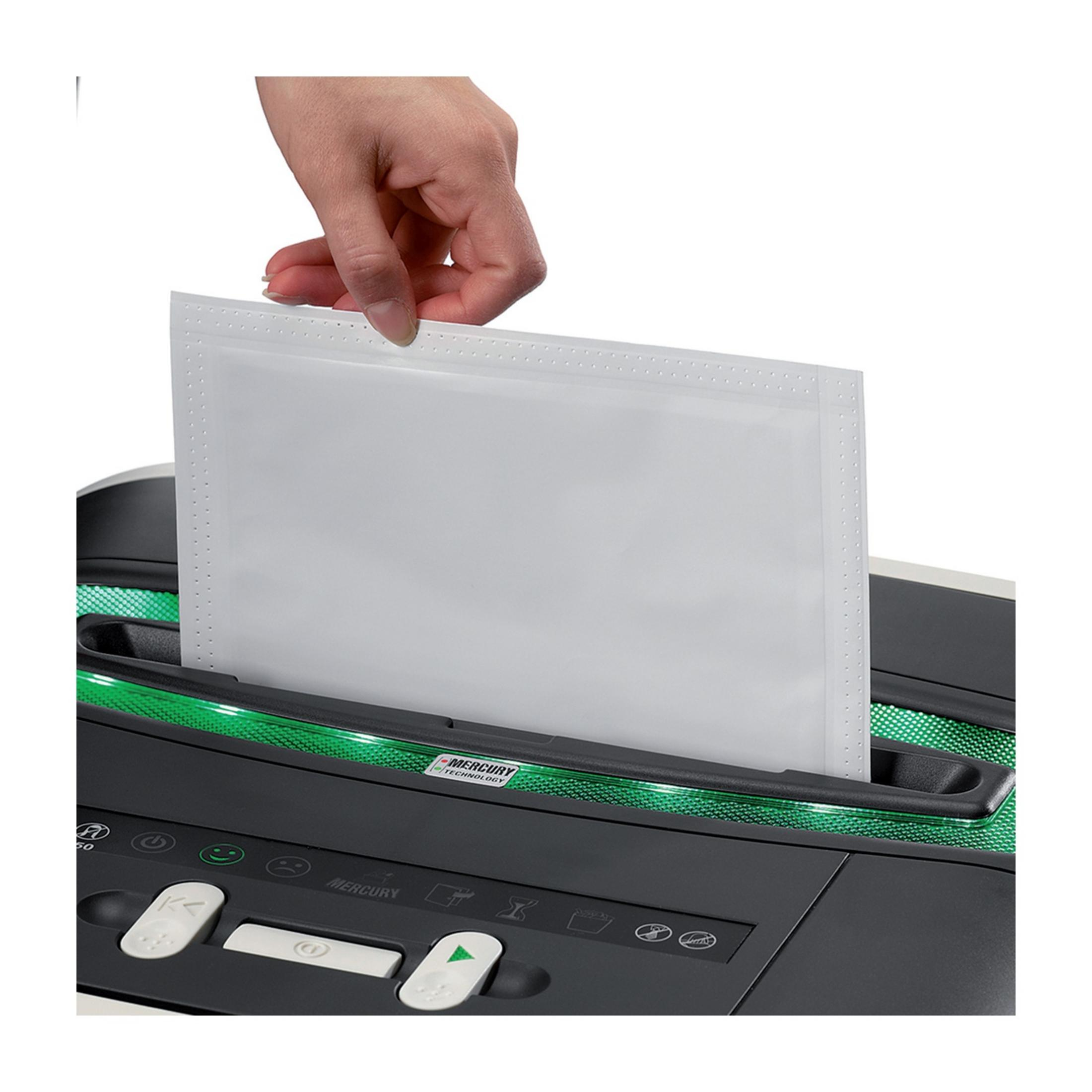 Una mano inserisce un foglio bianco in un distruggi documenti con illuminazione verde.