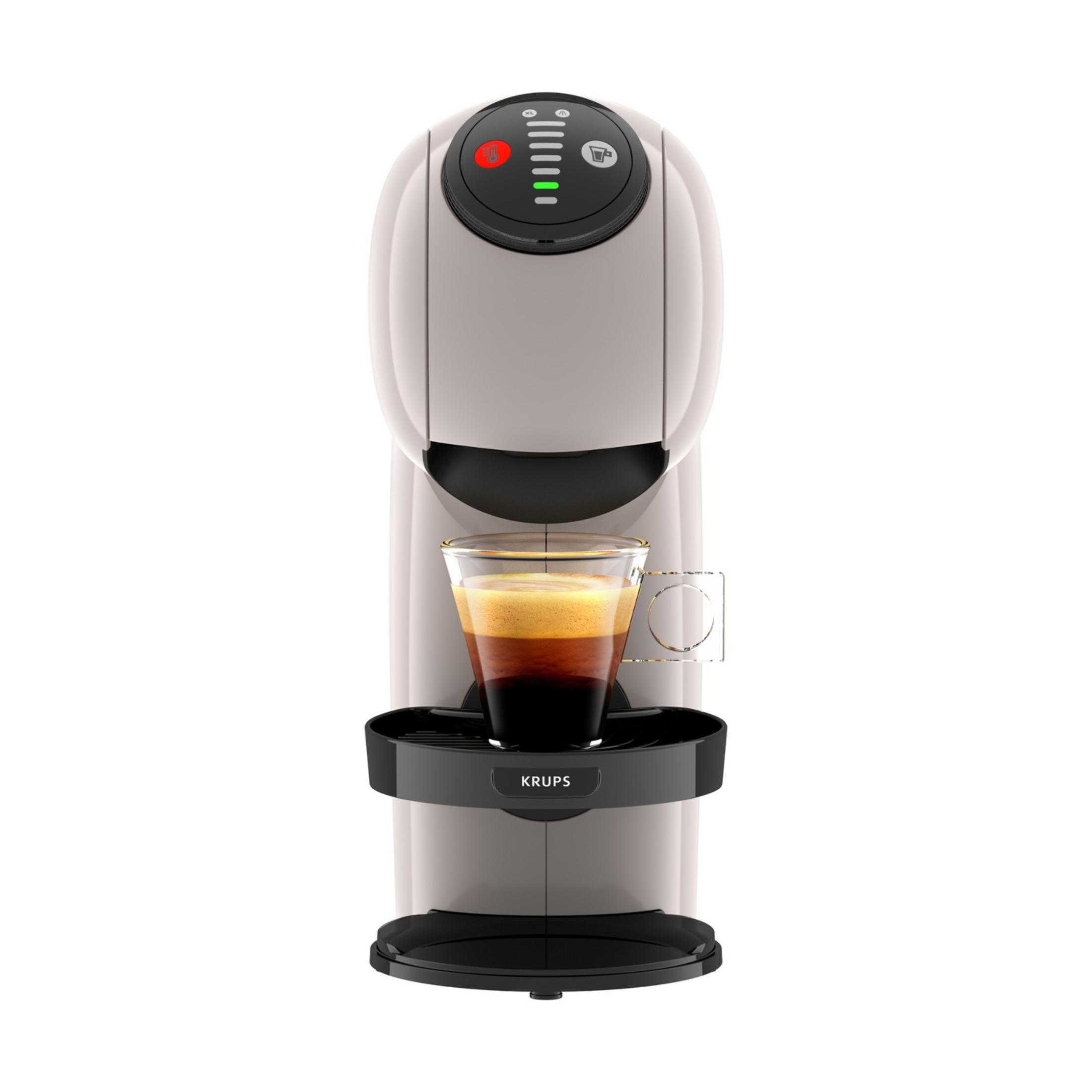 Eine weiße Kaffeemaschine mit einem Glas Espresso mit Schaum.
