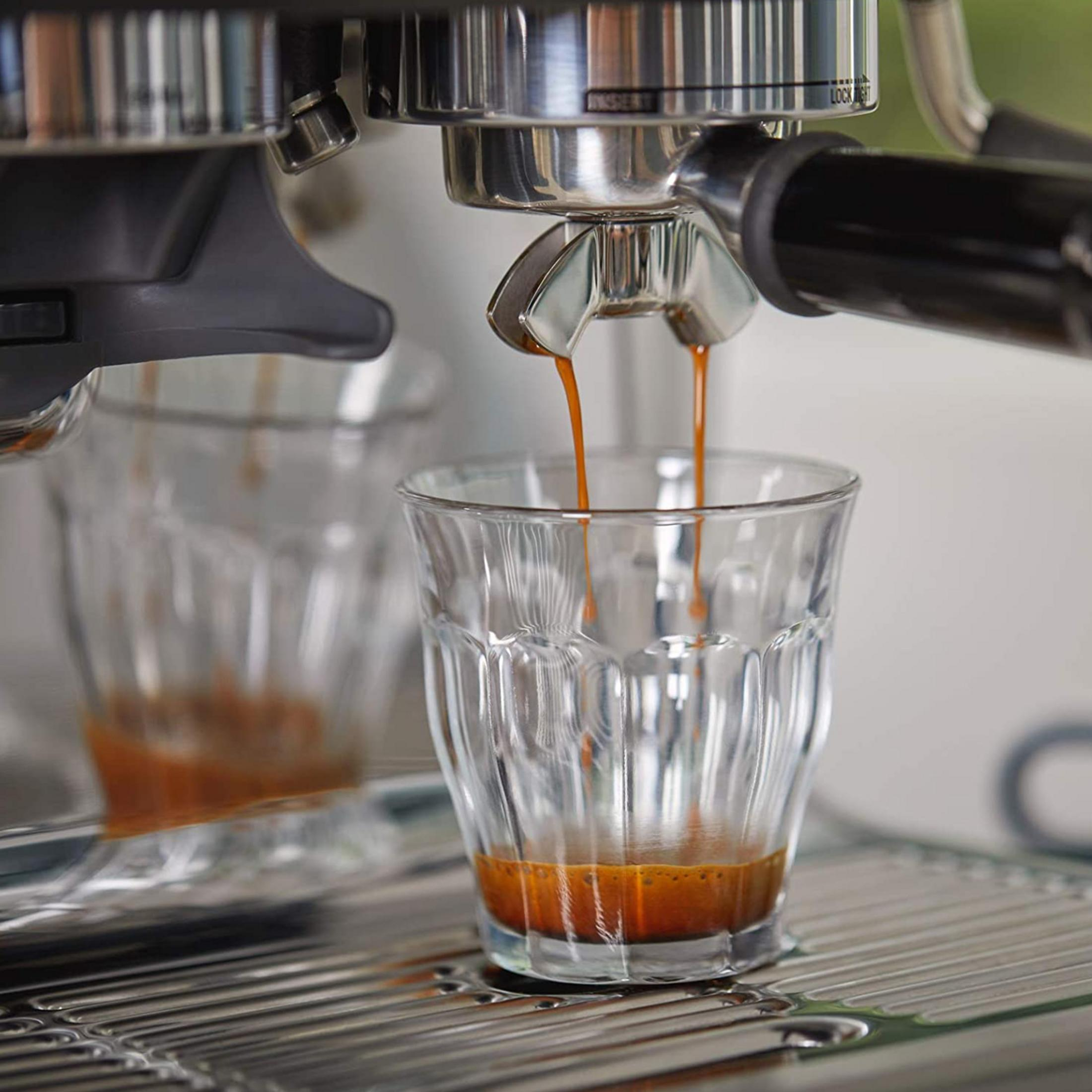 Espresso jest nalewane do szklanki na ekspresie do kawy.