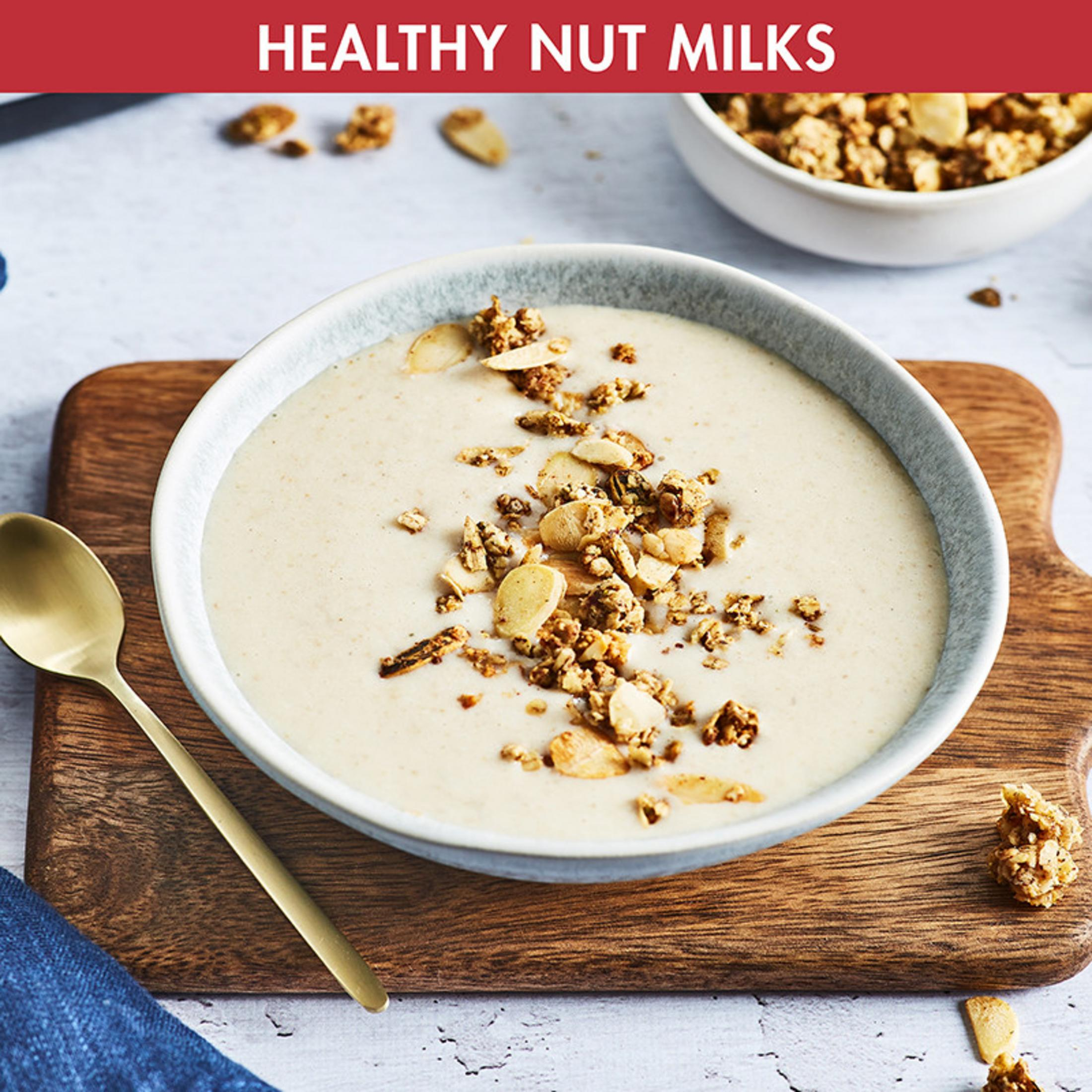 Eine Schüssel cremiger Haferflocken mit Nüssen und Granola, daneben ein Löffel.