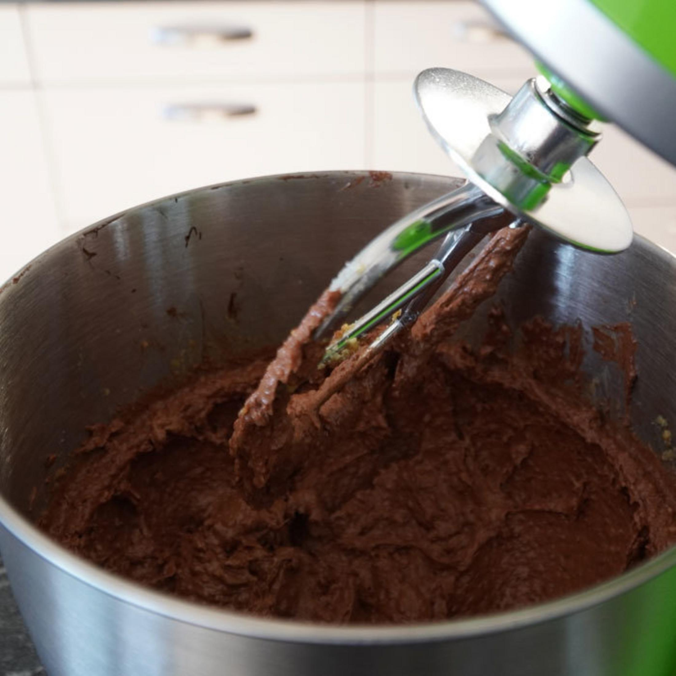Un impastatore verde mescola pastella marrone in una ciotola.