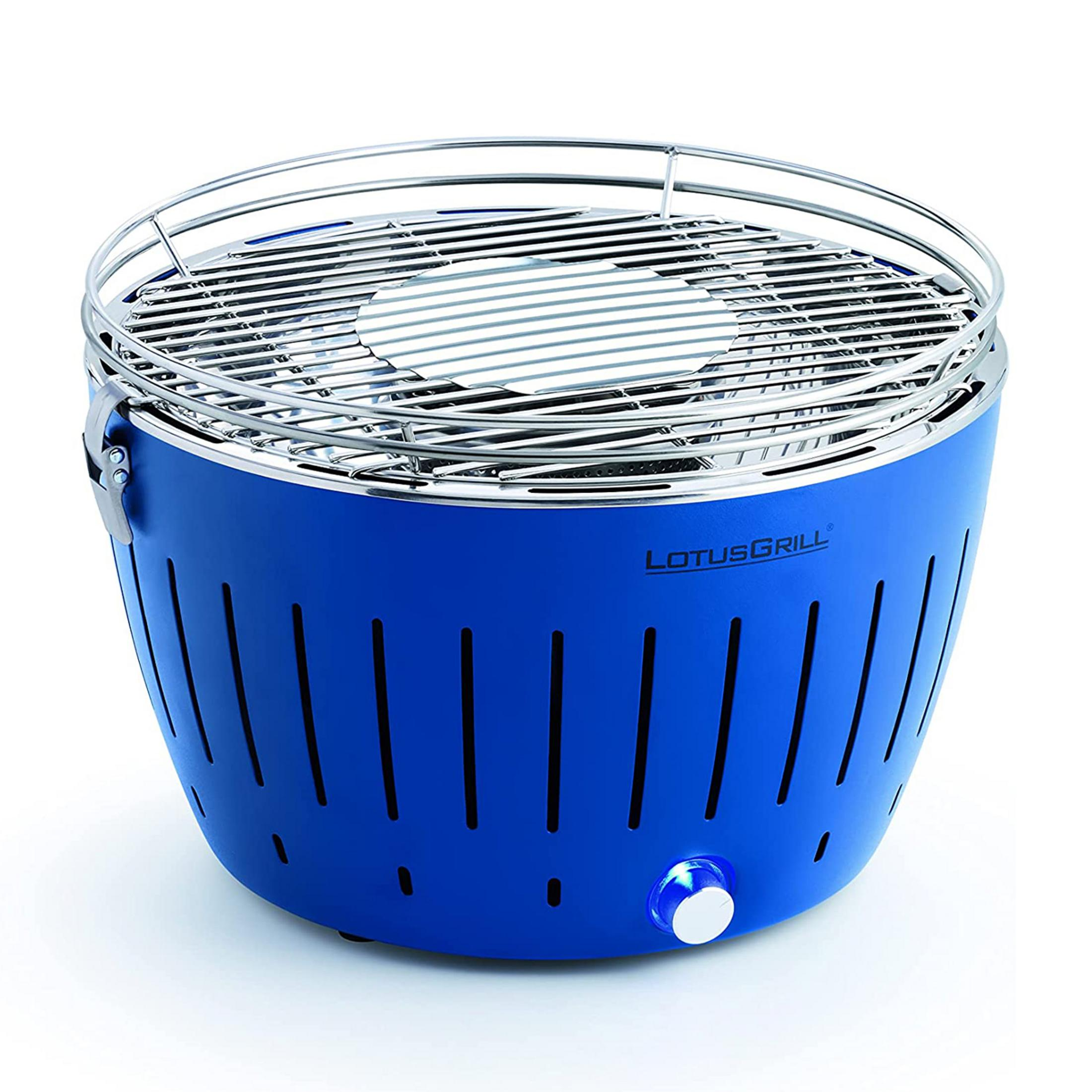 Niebieski grill LotusGrill z metalową kratką i białym pokrętłem.