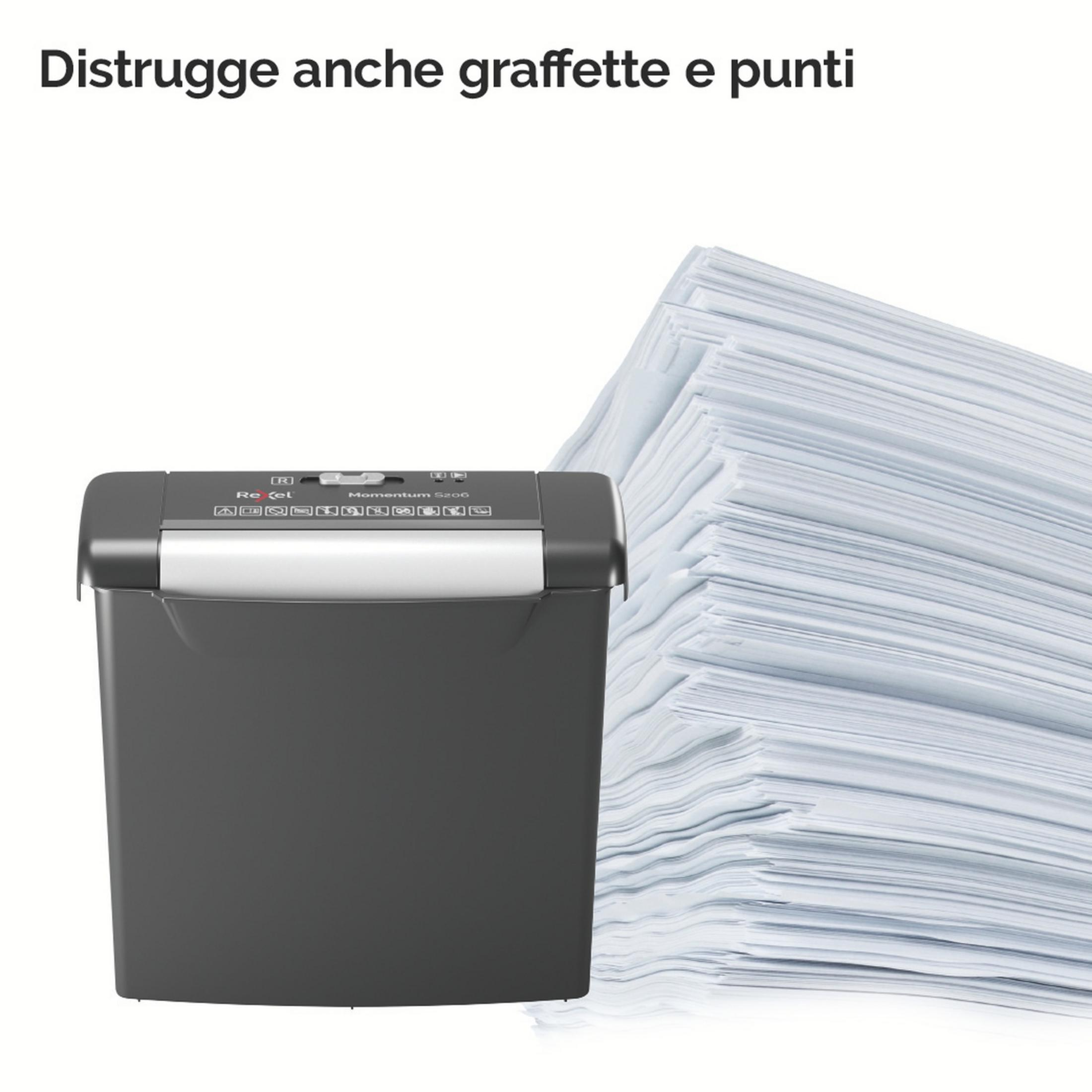 Ciemny niszczarka stoi obok dużej sterty białych papierów.