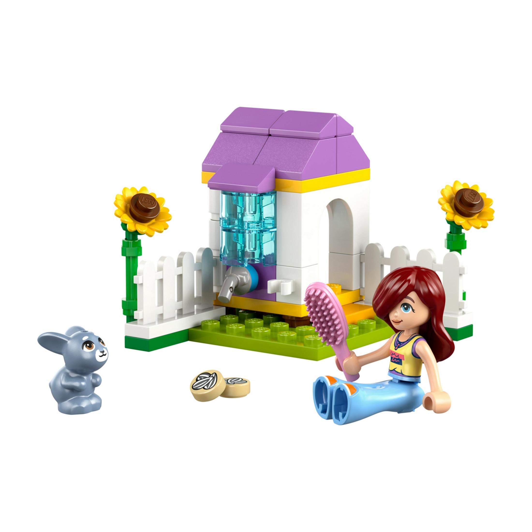 Una ragazza Lego con una spazzola vicino a un coniglietto e una casa con fiori.