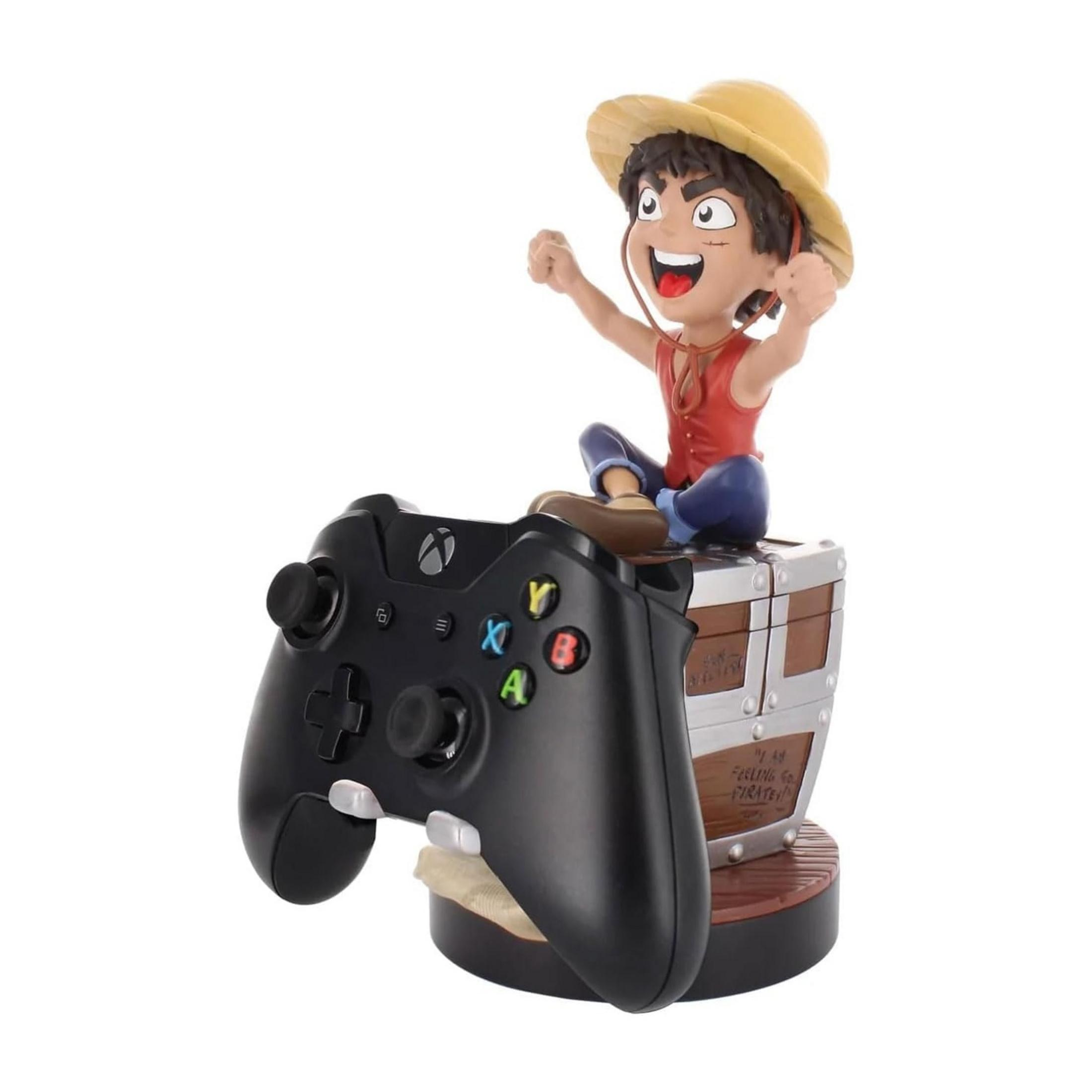 Un personaggio anime siede su un forziere accanto a un controller Xbox.