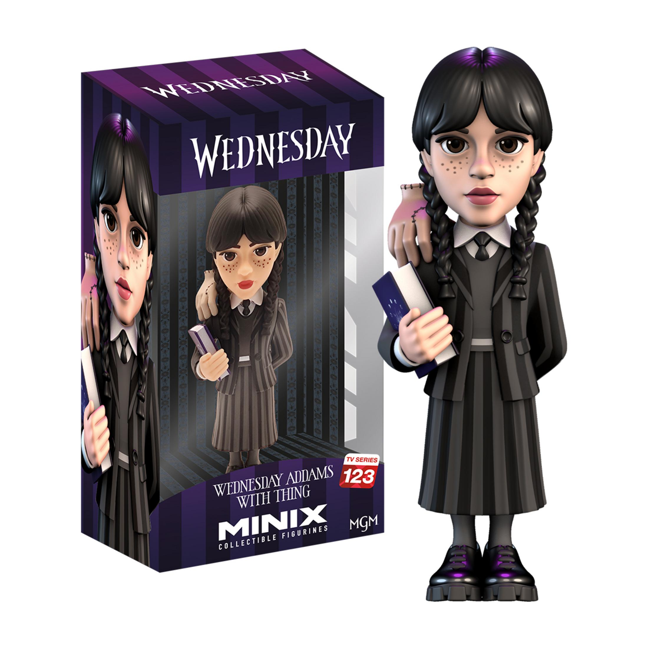 Statua di Mercoledì Addams con Mano. Indossa un abito nero a righe e tiene un libro.