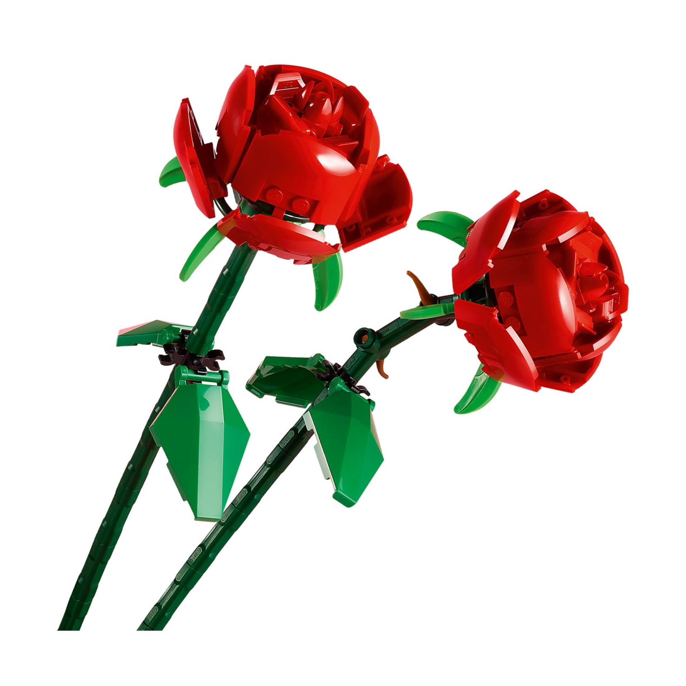 Dos rosas rojas de Lego con tallos y hojas verdes sobre fondo blanco.