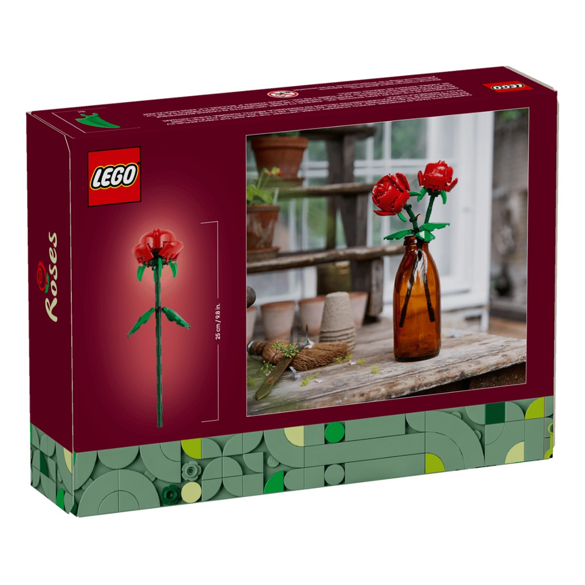 Embalaje del set LEGO Rosas con dos rosas LEGO rojas en una botella de vidrio marrón sobre mesa madera.