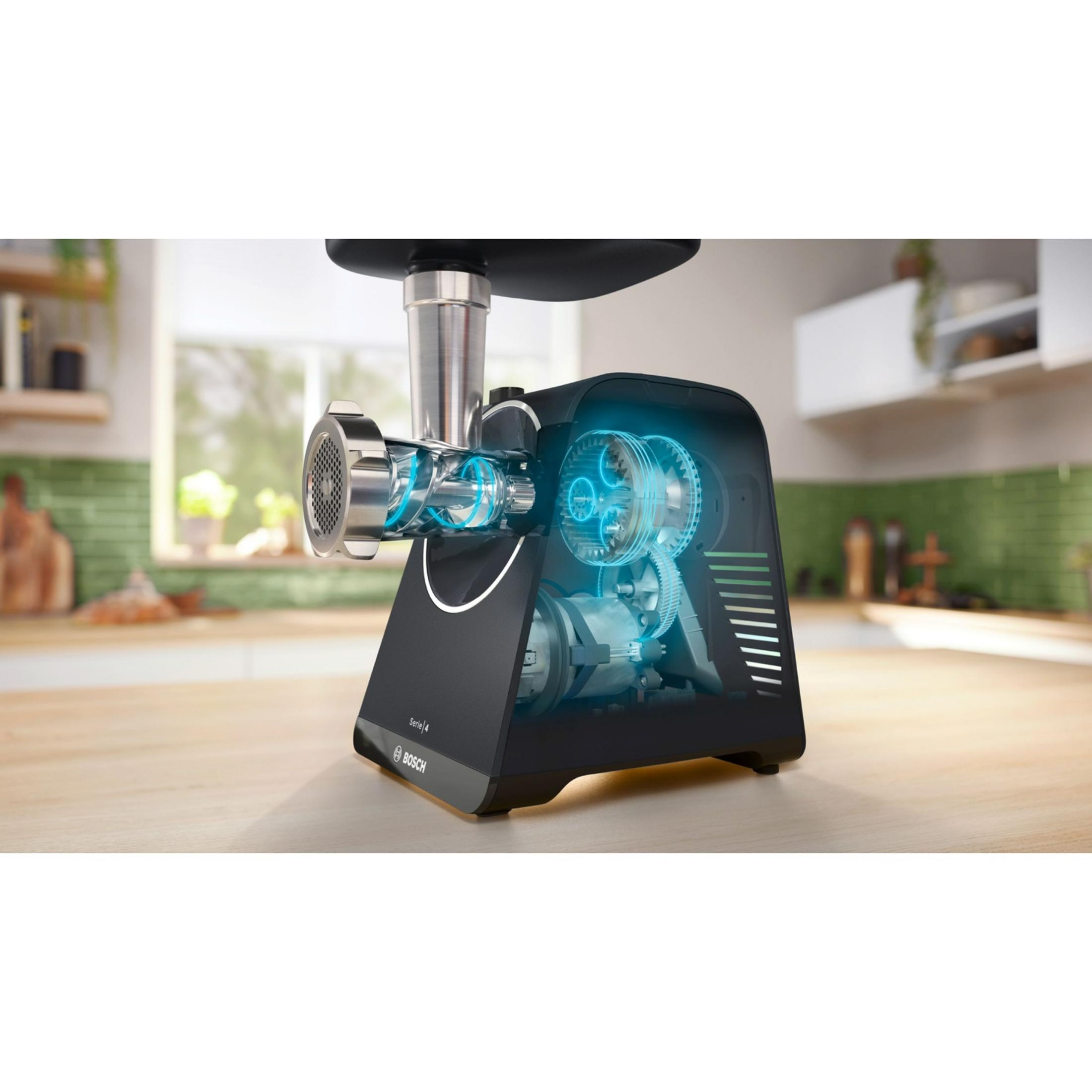 Młynek do mięsa z przezroczystą obudową pokazuje swoje niebieskie zębatki i silnik.