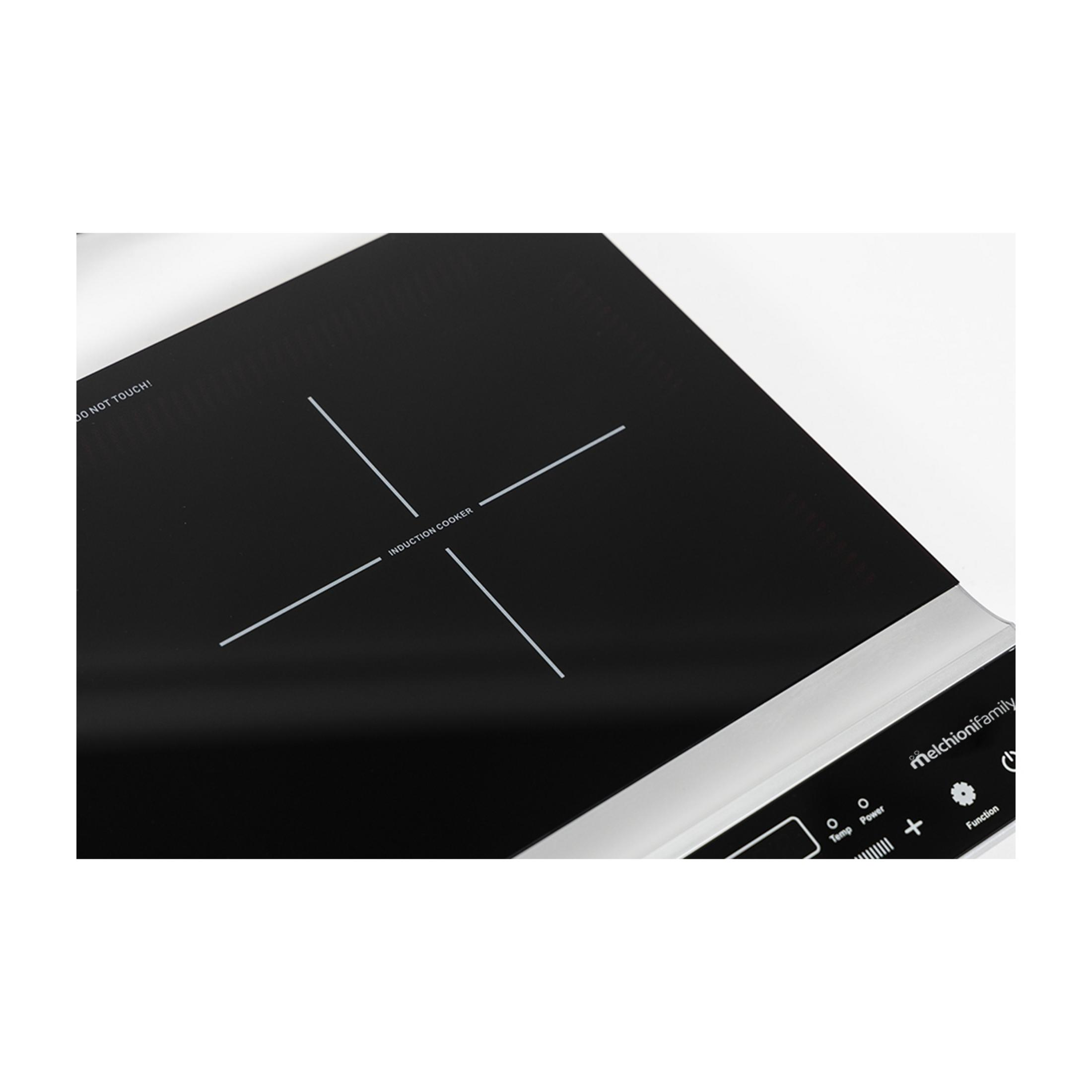 Placa de inducción negra con borde plateado y botones de control.