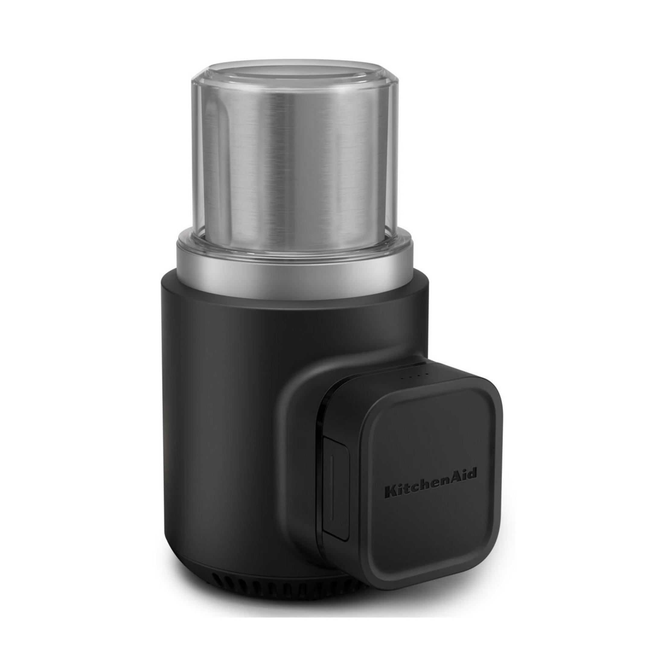 Czarny młynek do kawy KitchenAid ze stalową nakładką stoi na białym tle.