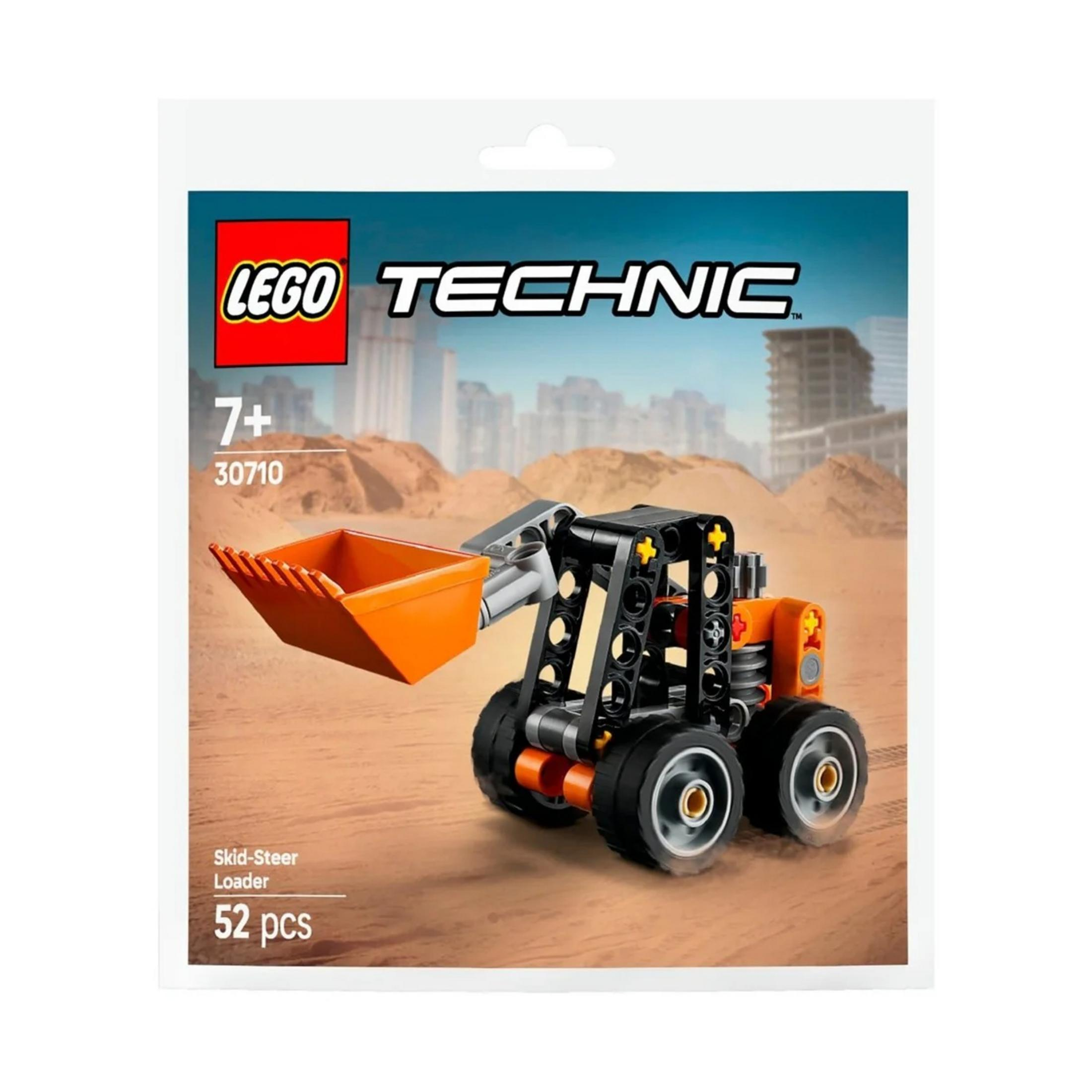 Pomarańczowa ładowarka Lego Technic typu skid-steer z łyżką na zakurzonej ziemi.