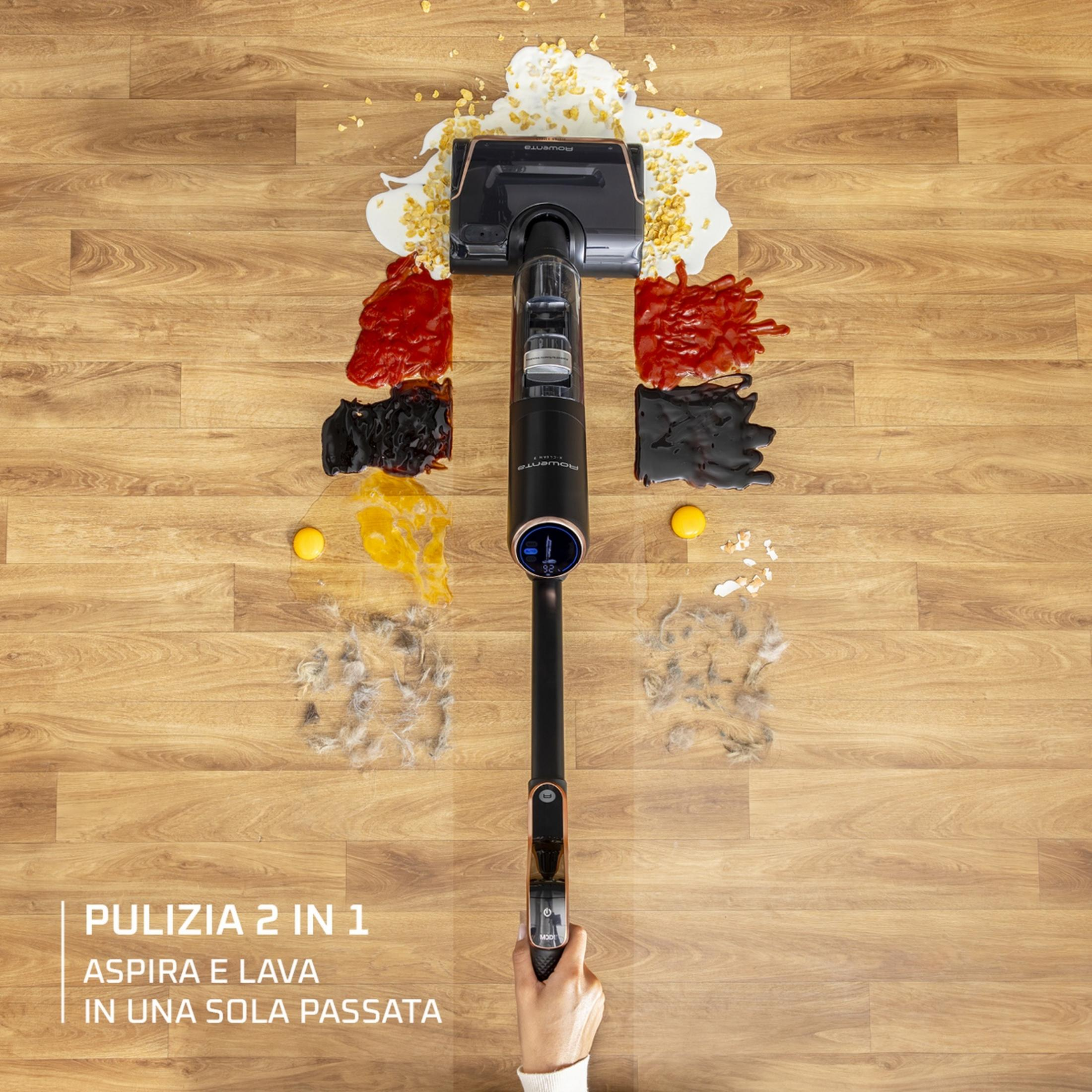 Una aspiradora sobre un suelo de madera con comida derramada y pelo.
