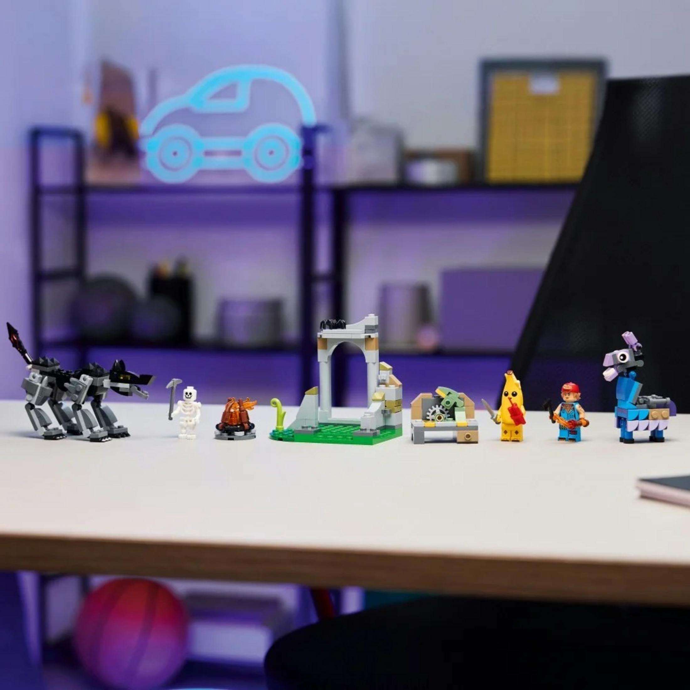 Masanın üzerinde renkli Lego figürleri ve yapıları, kurt, iskelet, lama ve muz adam dahil.
