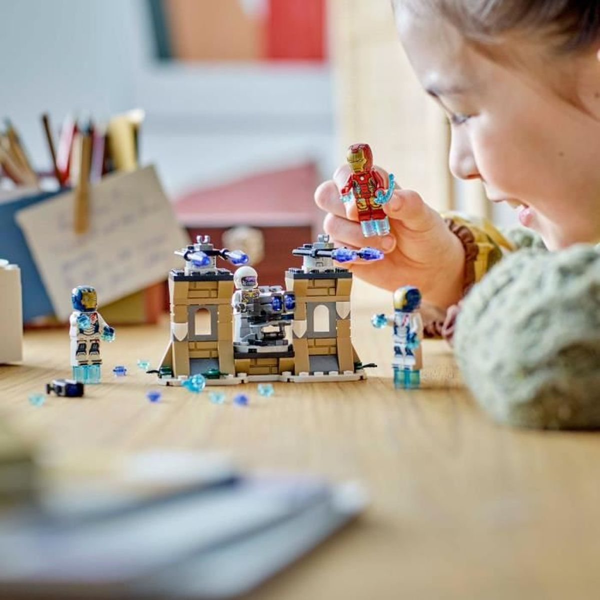 Dziecko bawi się figurkami Lego Iron Mana i astronautów.