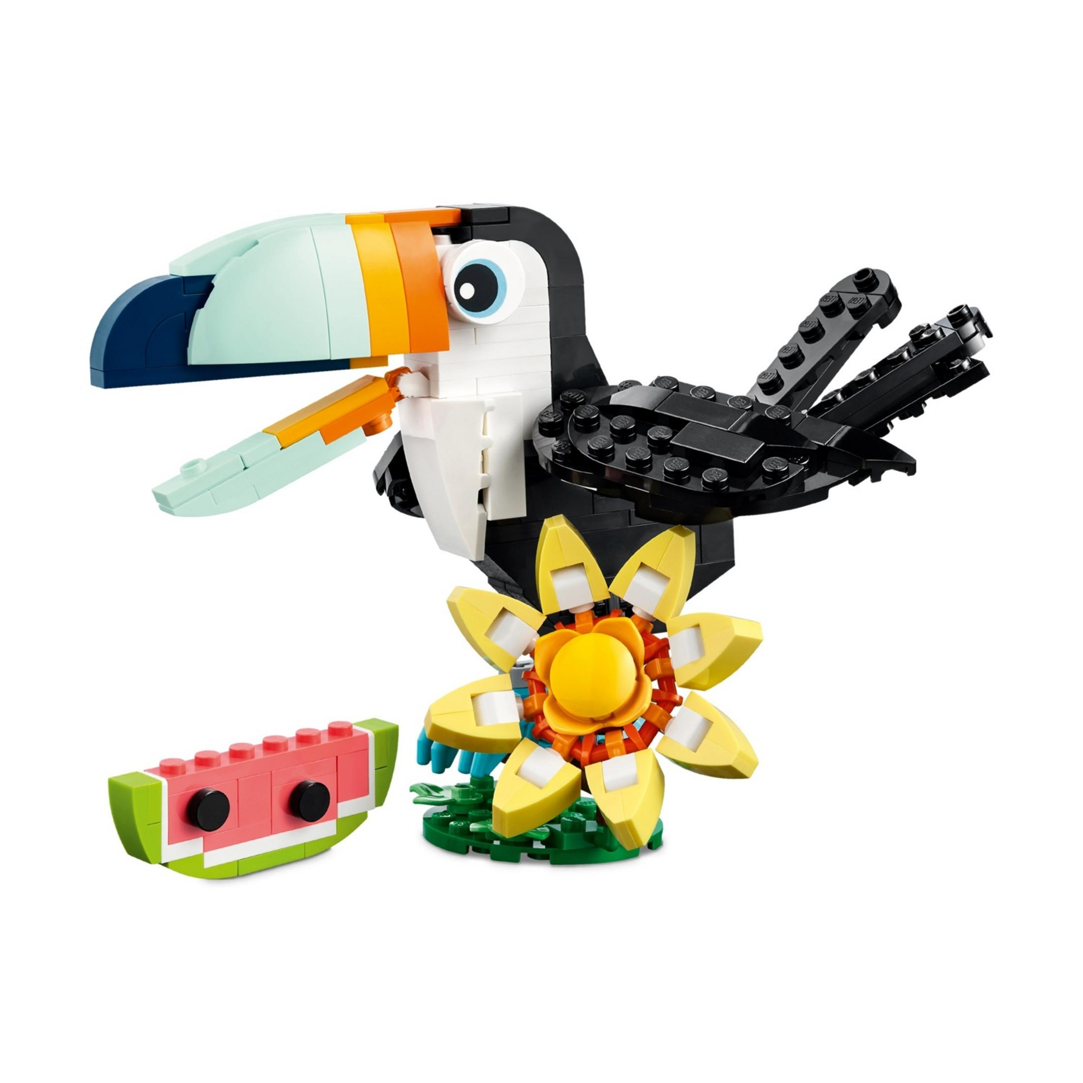 Kolorowy tukana Lego siedzi obok kwiatu i kawałka arbuza.