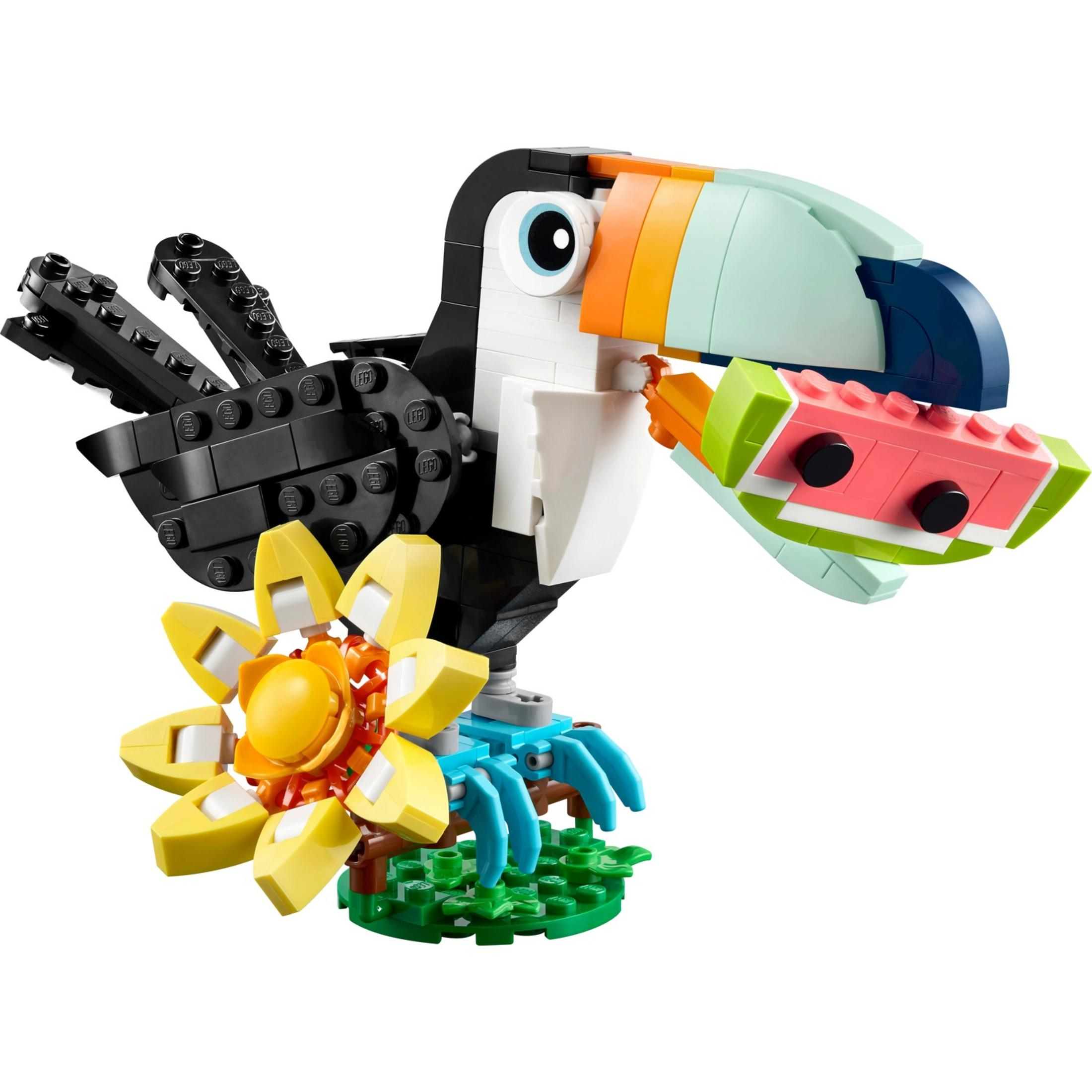 Tukan z klocków Lego trzymający plasterek arbuza, z kwiatową podstawą.