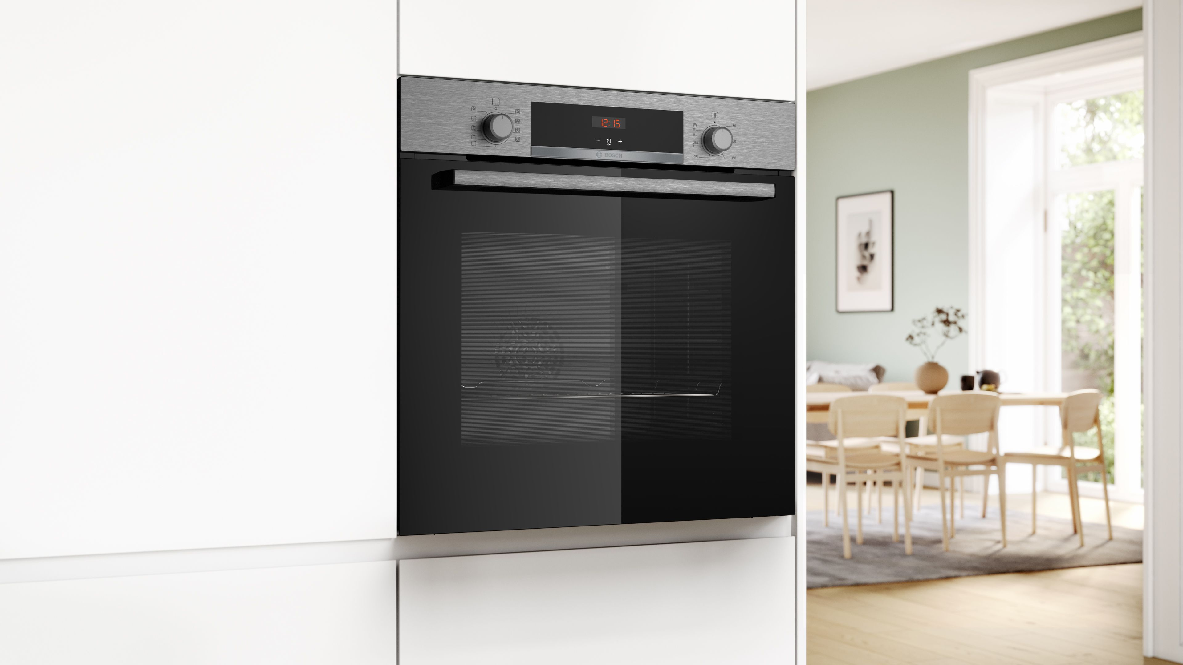 Een moderne inbouwoven in een keuken met een eethoek op de achtergrond.