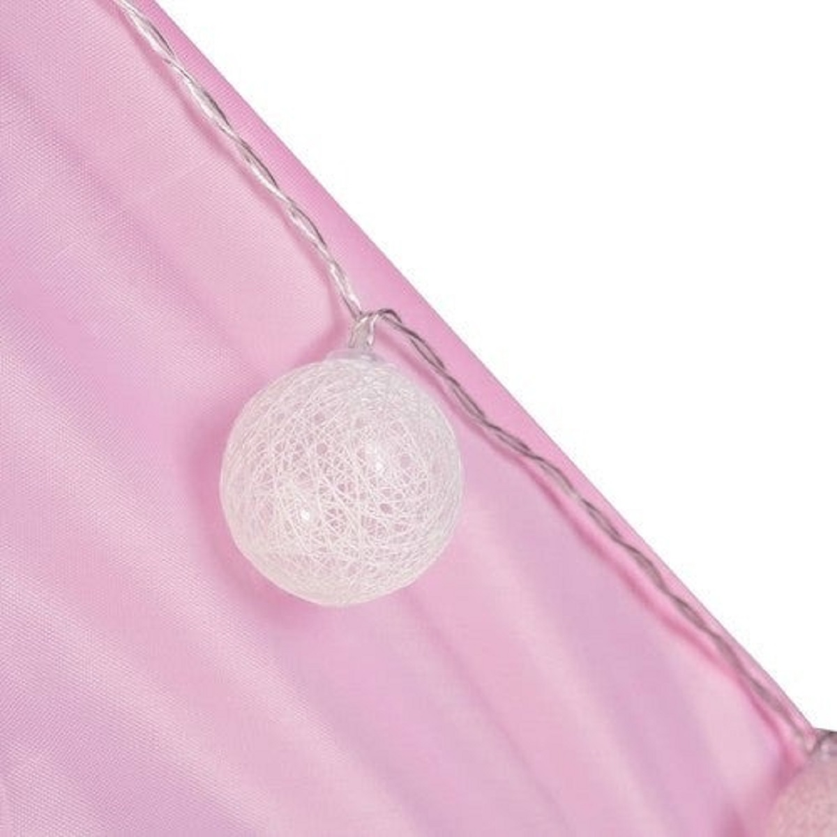Cadena de luces blanca con bolas sobre tela rosa.