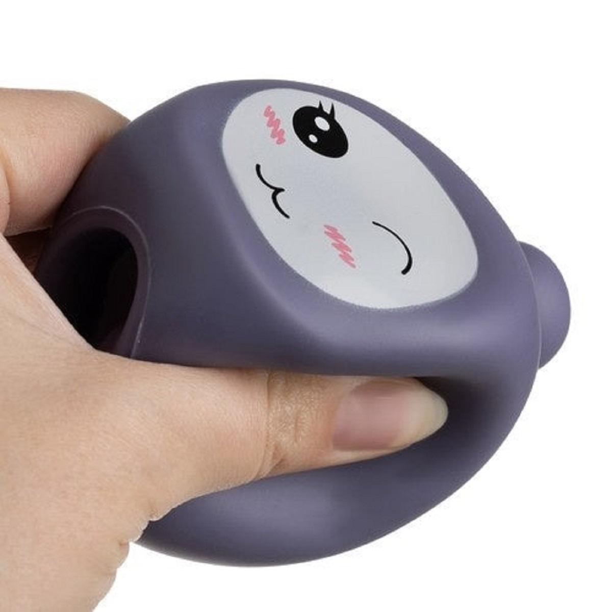 Una mano aprieta una pelota antiestrés morada con cara linda.