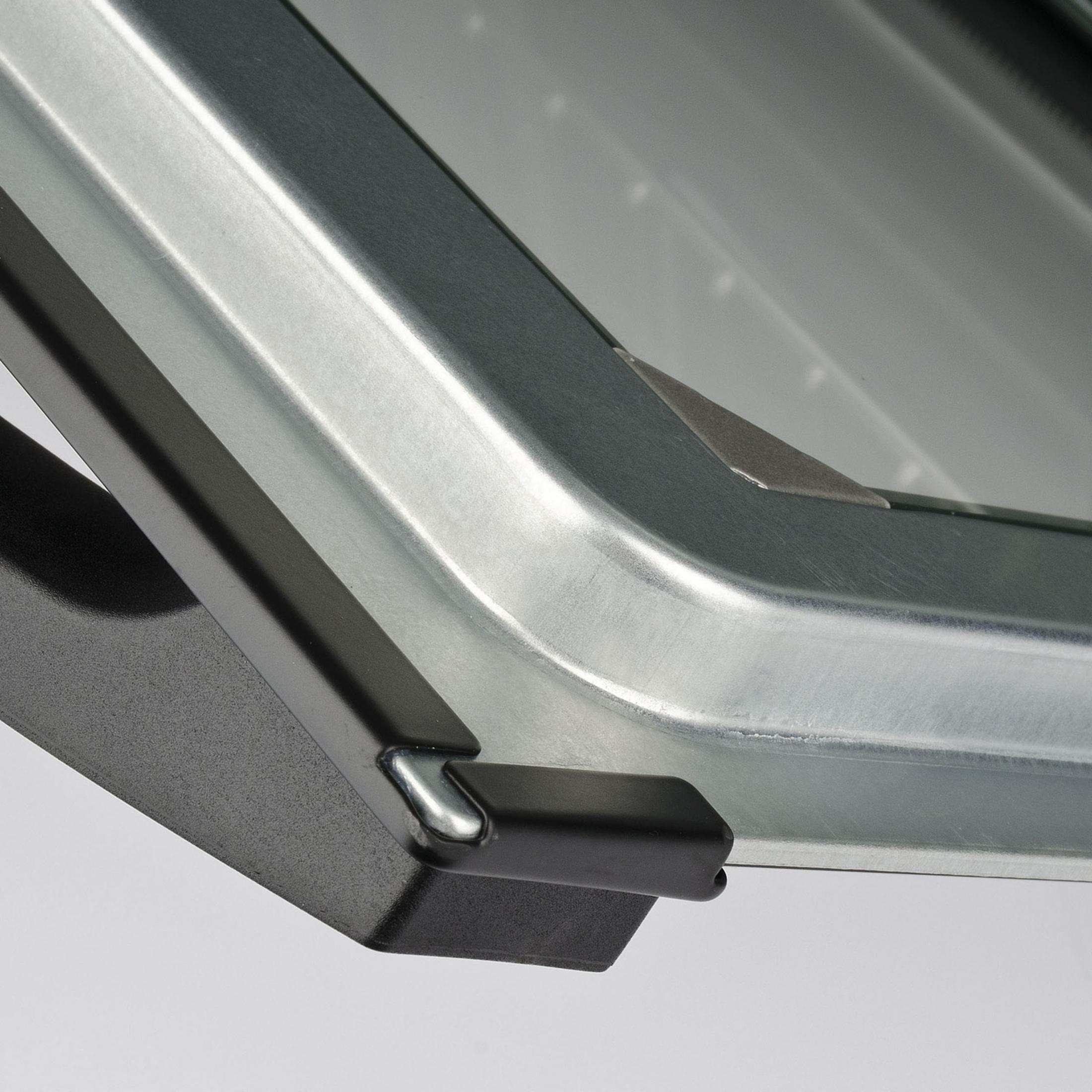 Detailansicht einer Metallkante mit schwarzem Griff und silbernem Hintergrund.