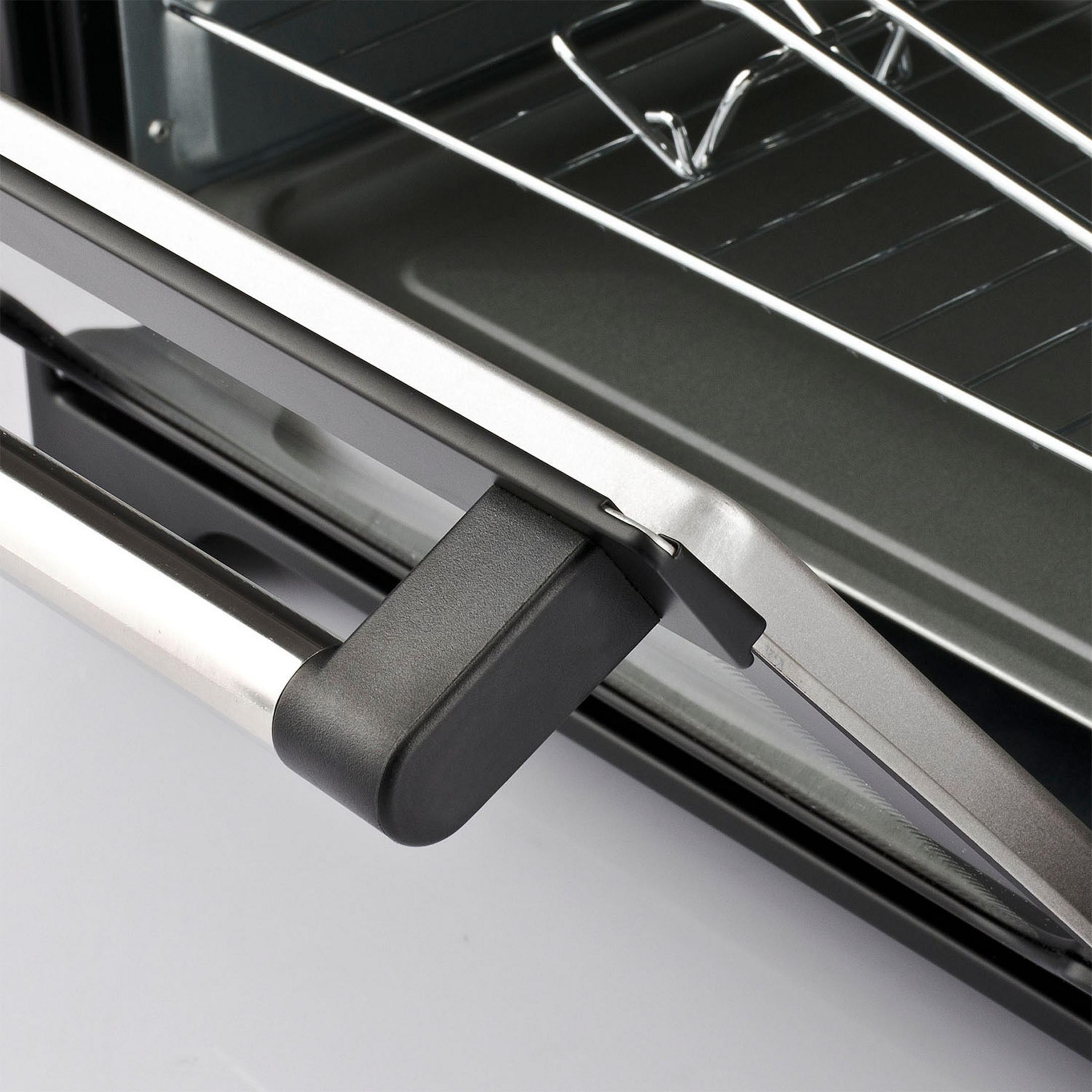 Zbliżenie otwartej klamki drzwi piekarnika, z metalu i czarnego plastiku.