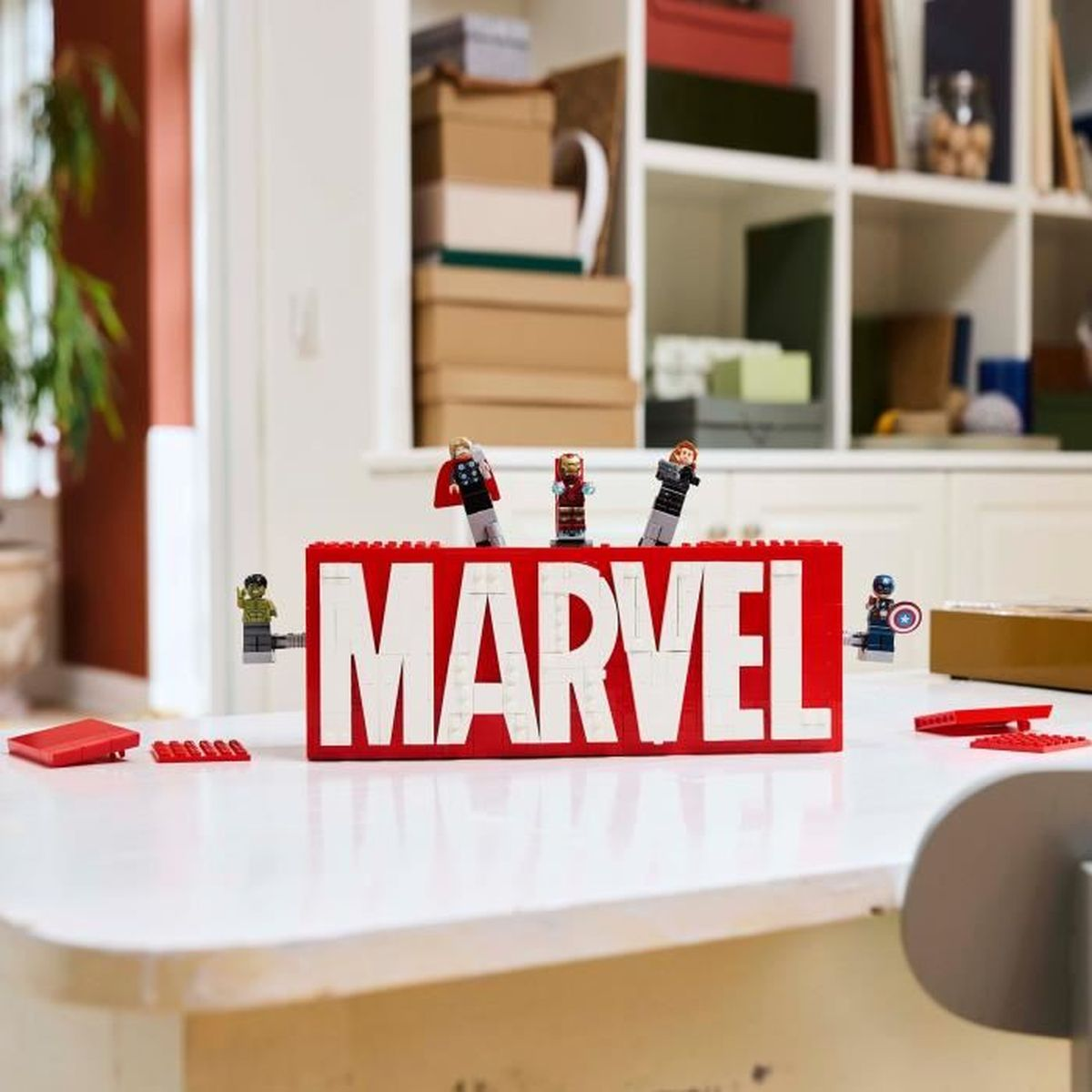 Figurki Lego bohaterów Marvel na czerwonym napisie Lego MARVEL.