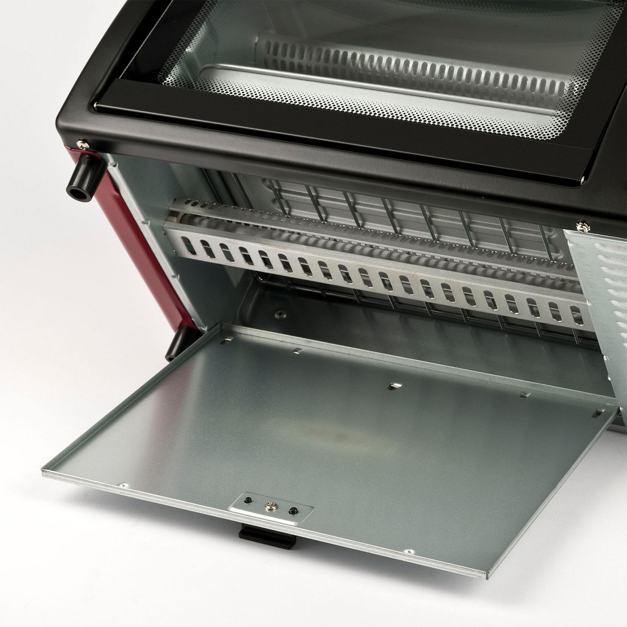 Czerwony piekarnik z otwartymi drzwiczkami, pokazujący elementy grzewcze i ruszt.