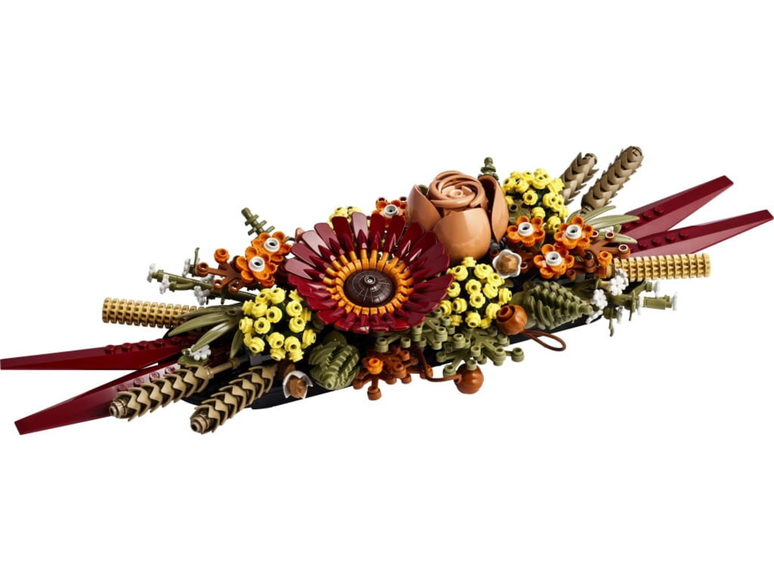 Un arrangement floral LEGO avec une fleur rouge, une rose marron et des fleurs jaunes.
