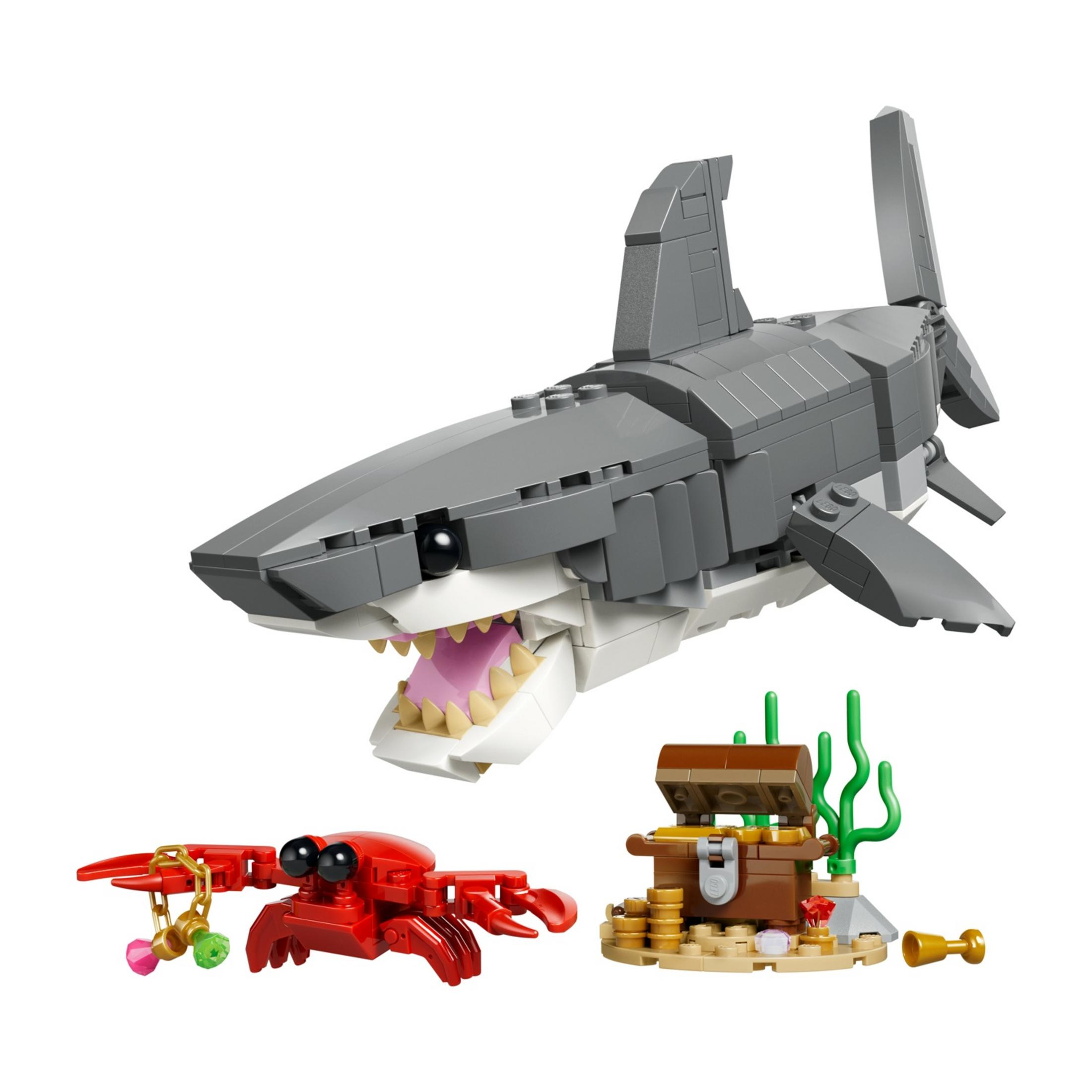 Un tiburón, cangrejo y cofre del tesoro de Lego con monedas y coral.