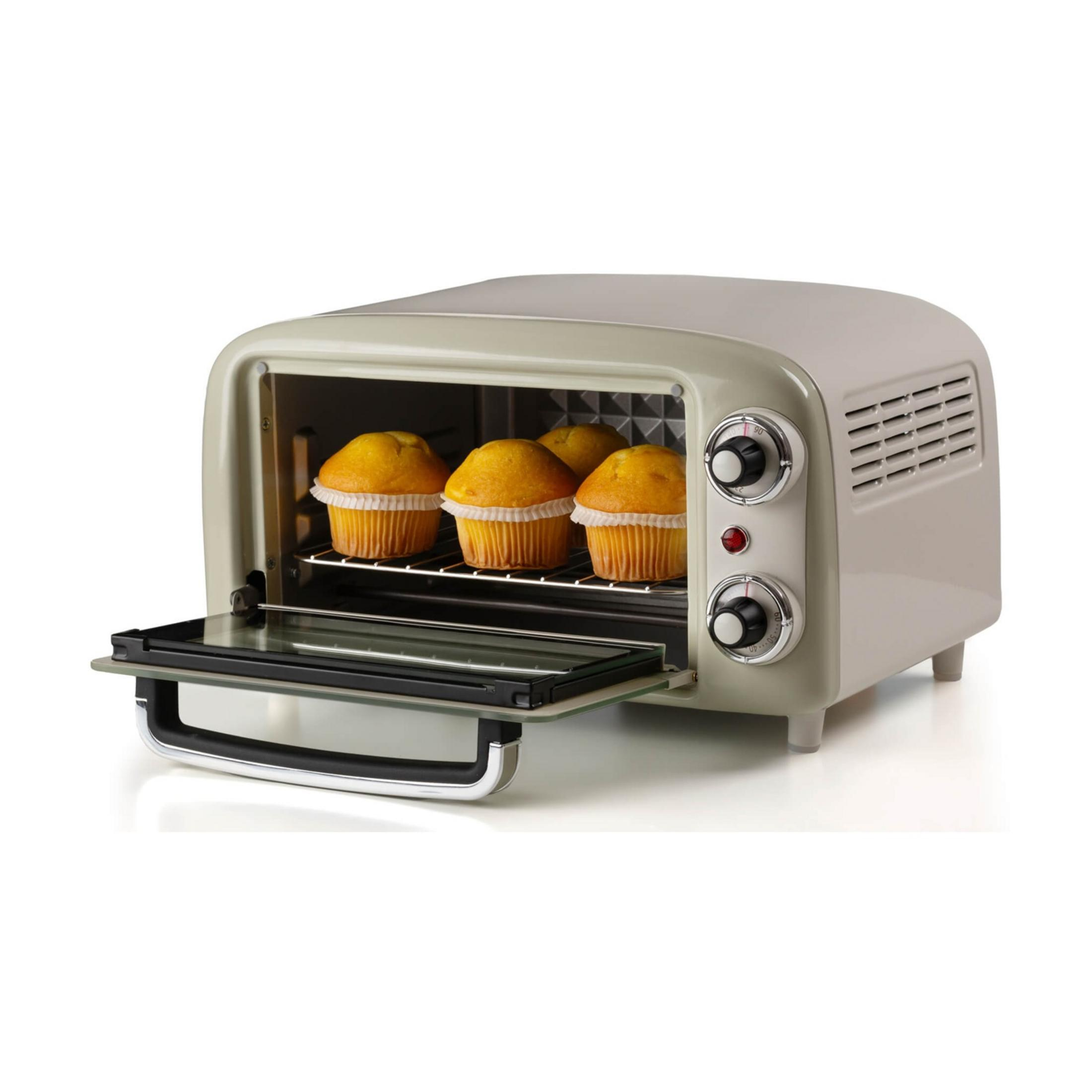 Kremowy piekarnik tostera z otwartymi drzwiczkami, pokazujący cztery muffiny na ruszcie.