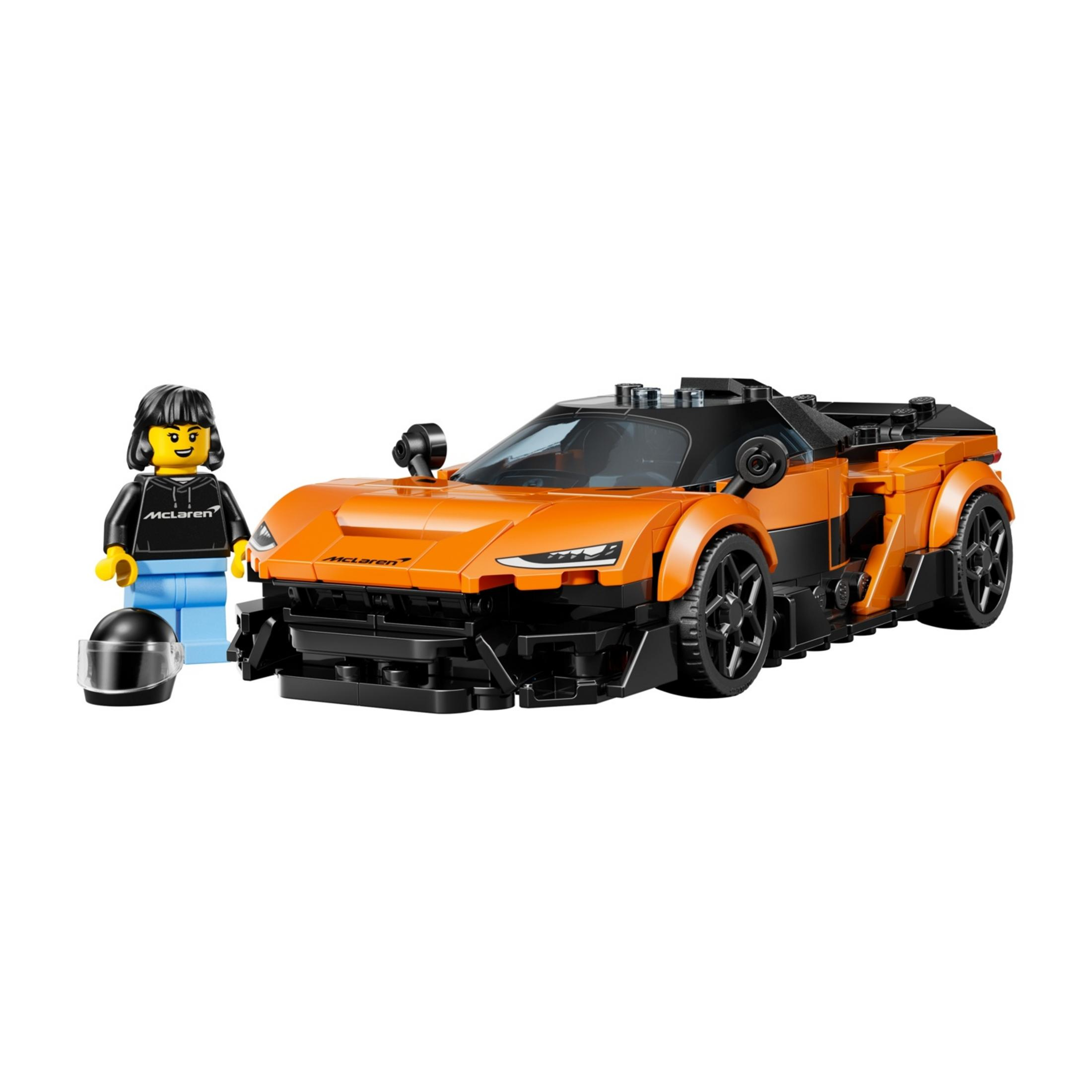Un coche deportivo McLaren naranja de Lego junto a una minifigura con casco.