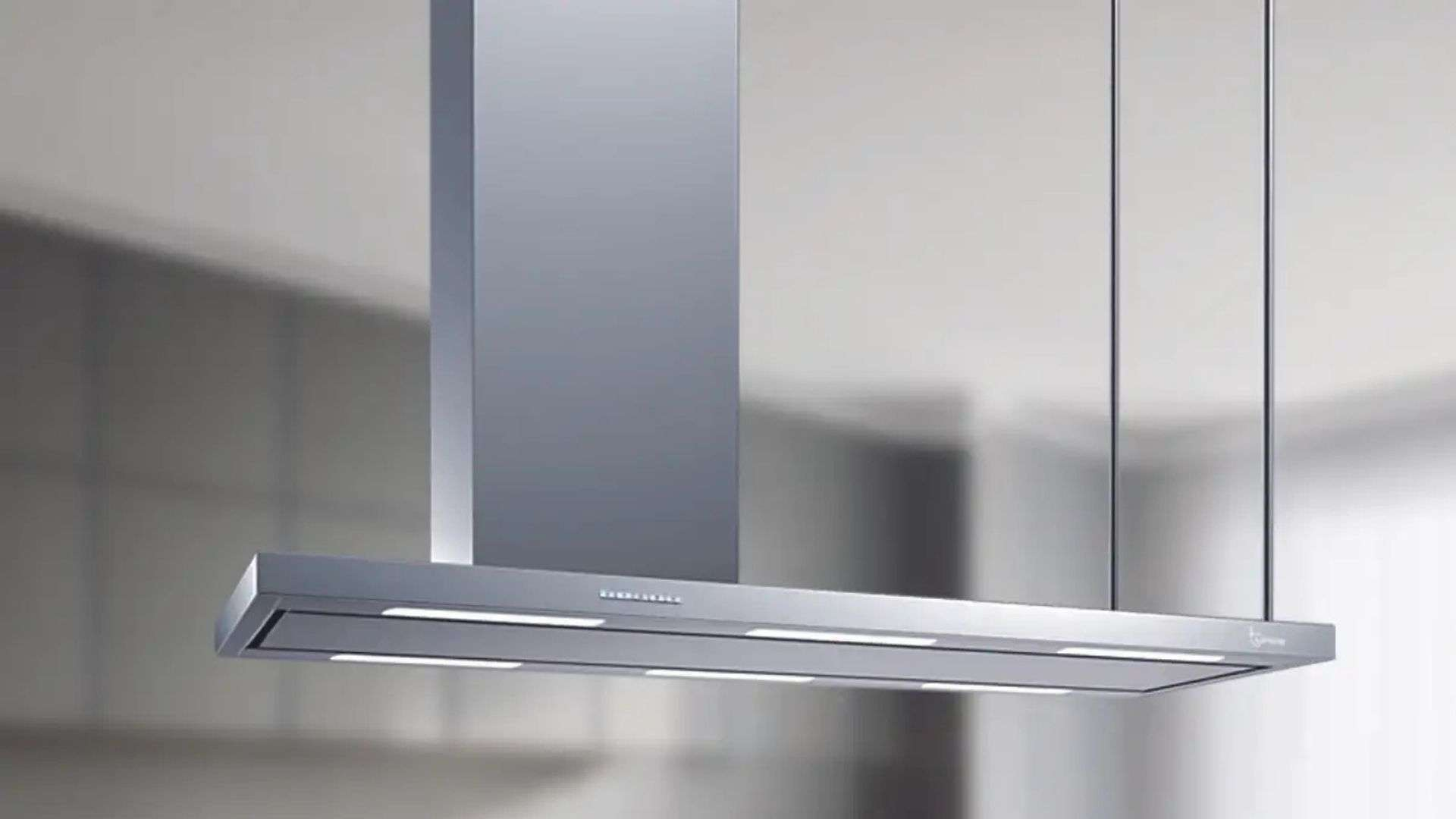 Una moderna cappa in acciaio inox pende dal soffitto.