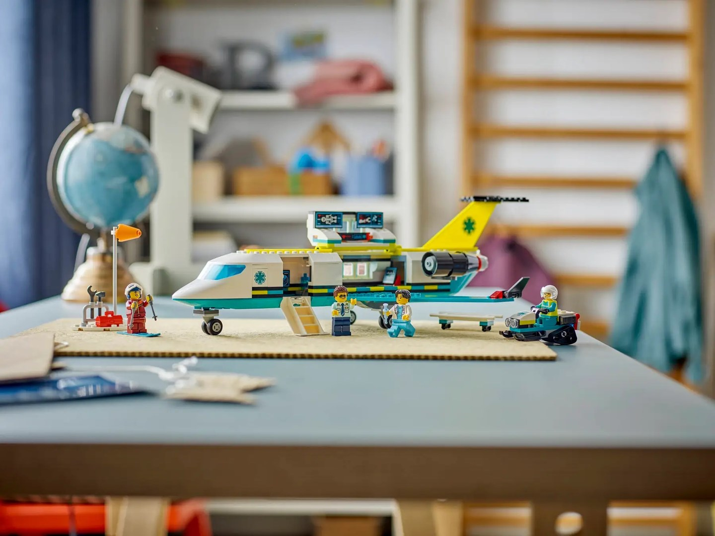 Zabawkowy samolot z figurkami i akcesoriami na stole.