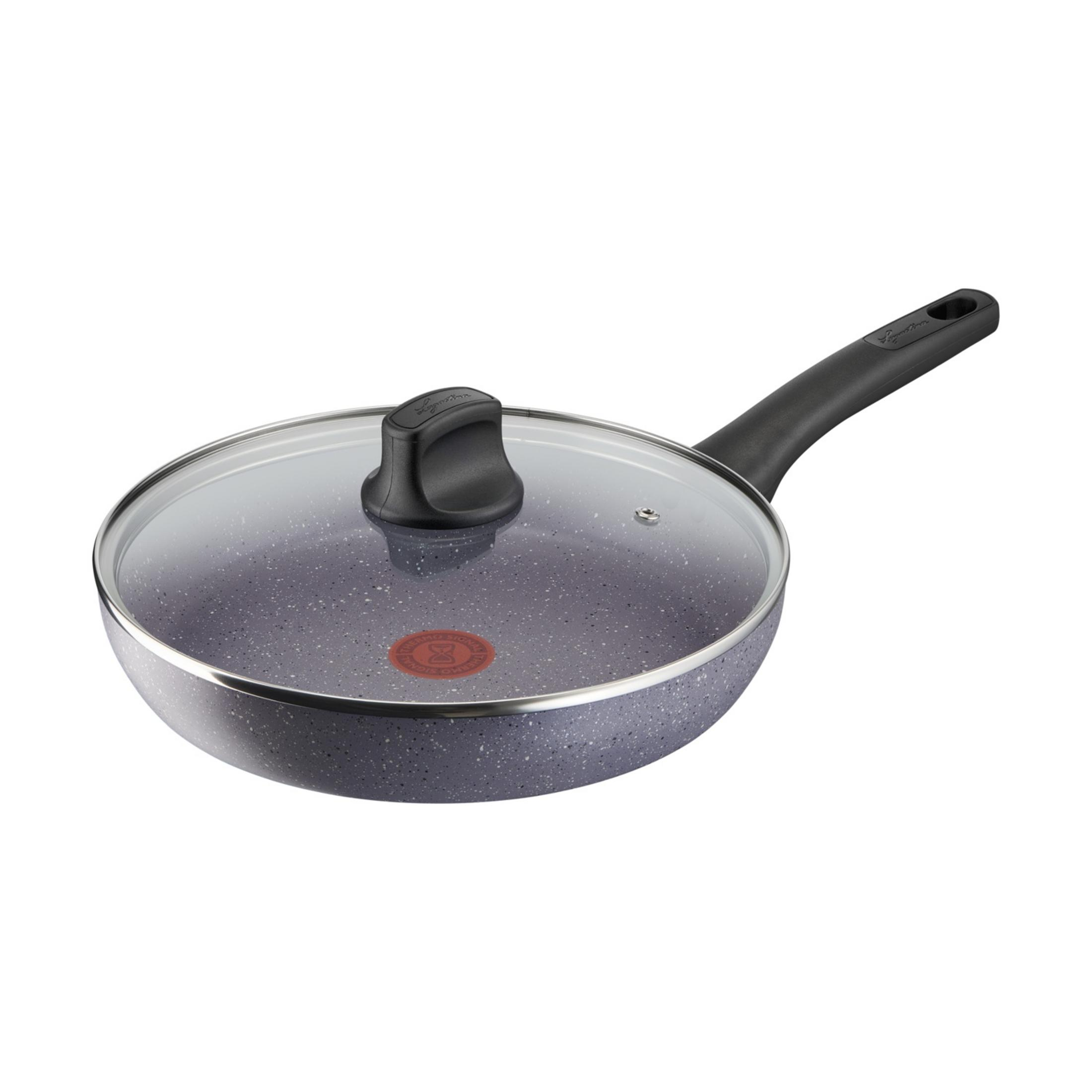 Sartén gris con tapa de cristal y mango negro.