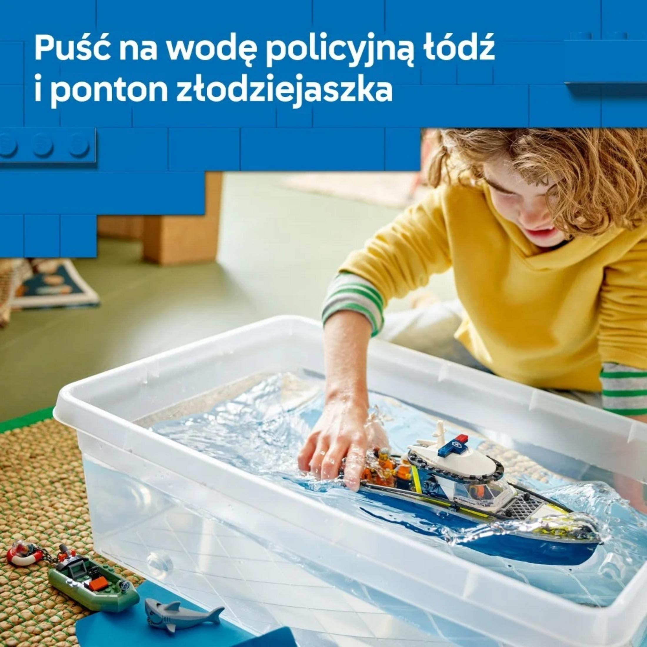Dziecko bawi się zabawką łodzi policyjnej w wannie z wodą.