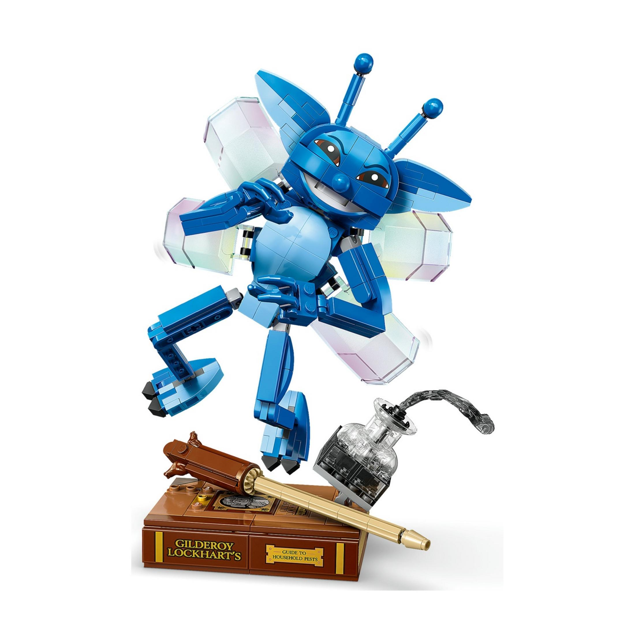 Niebieska figurka mitycznego stworzenia Lego z półprzezroczystymi skrzydłami stoi na książce.