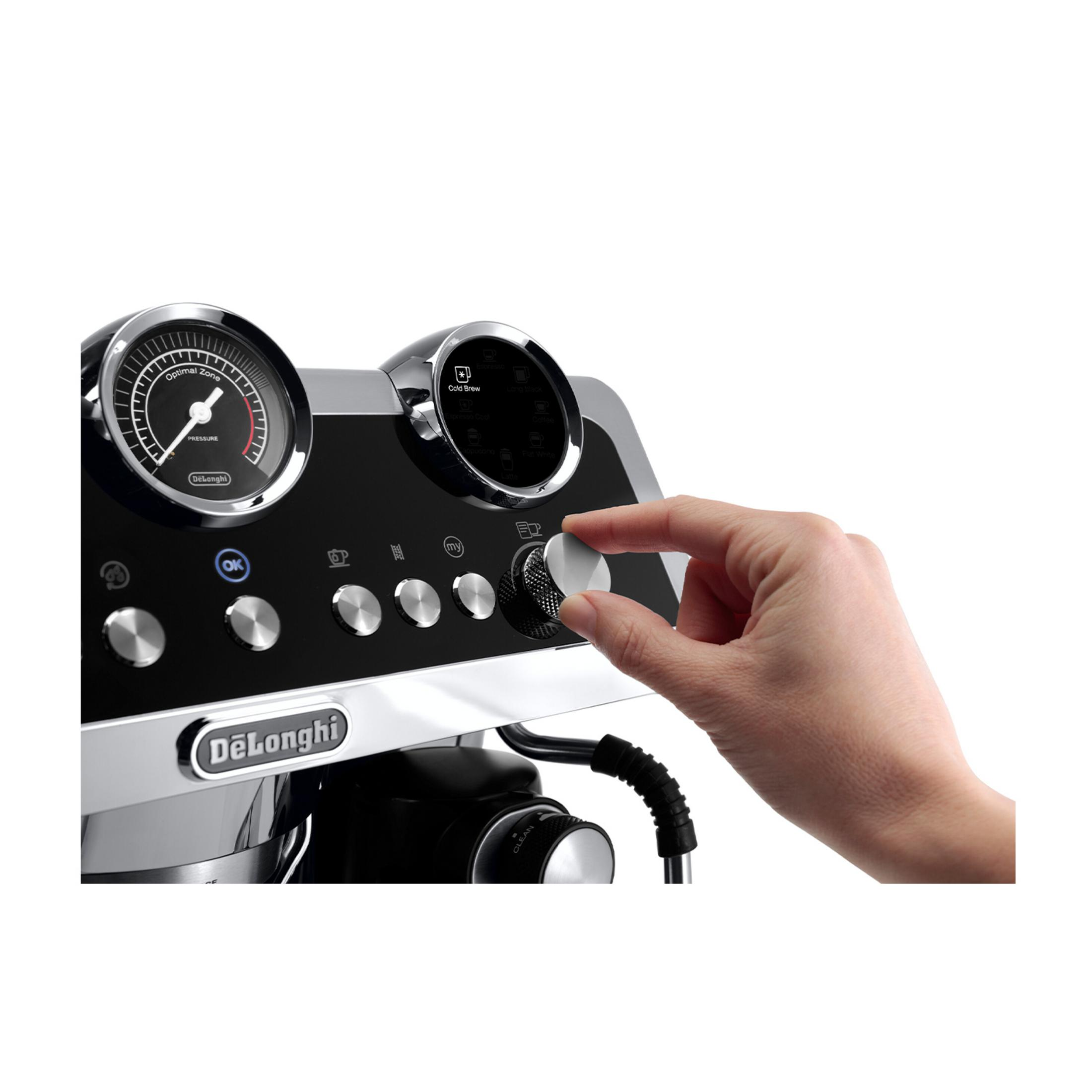 Eine Hand dreht an einem silbernen Knopf einer Kaffeemaschine mit Display.