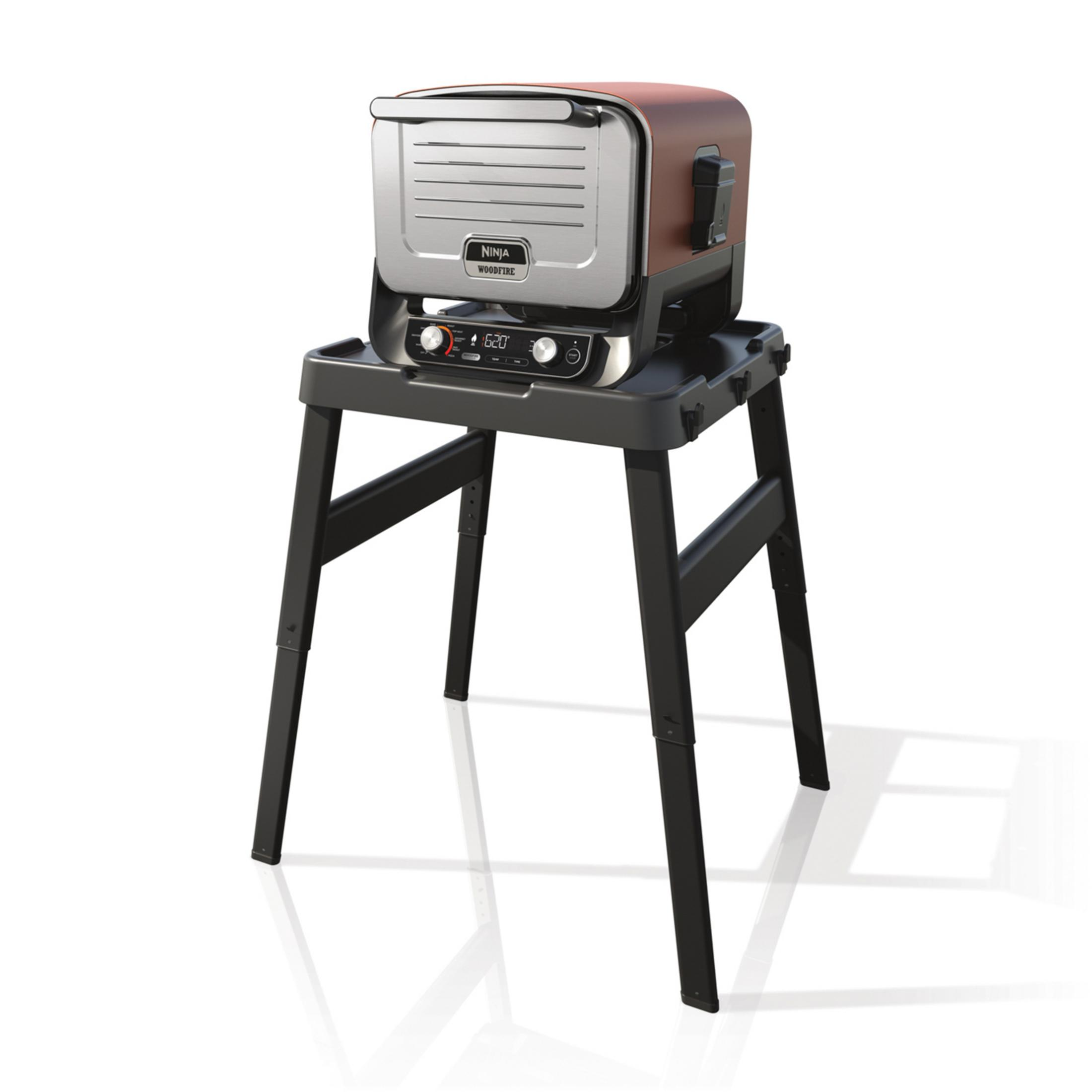 Un grill Ninja Woodfire sur un support noir, isolé sur fond blanc.