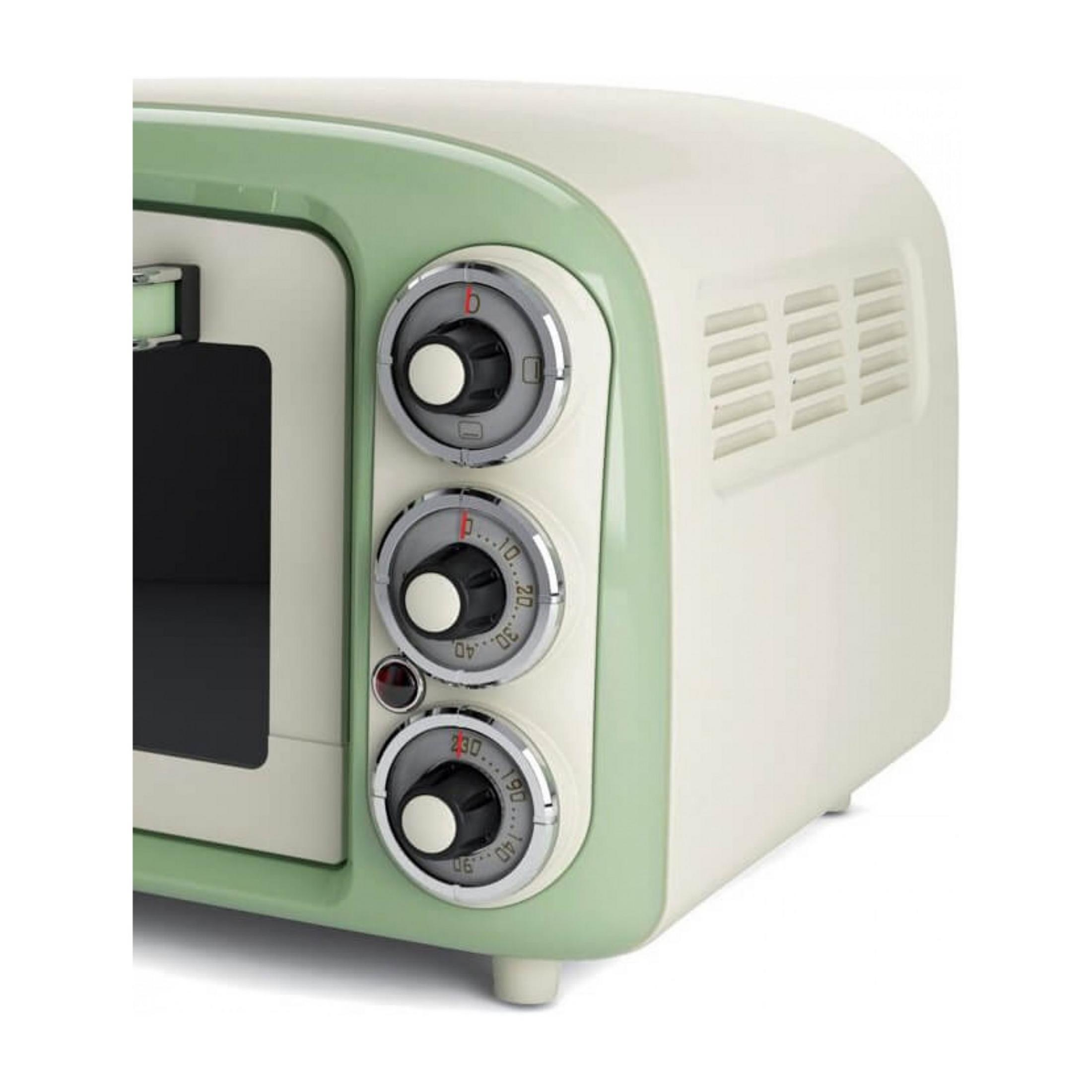 Kremowo-zielony piekarnik retro z trzema pokrętłami i okienkiem.